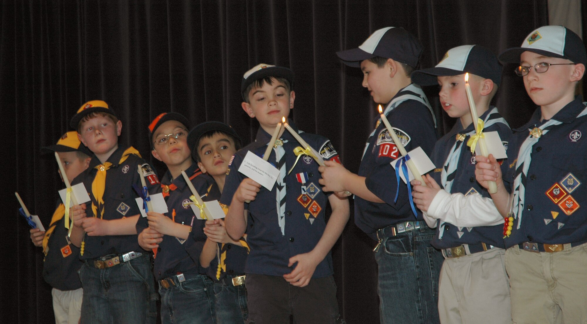 MOUNTAIN HOME AIR FORCE BASE, Idaho -- Cub Scouts perform the candle lighting ceremony, March 8 at the Mountain Home Air Force Base Cub Scouts, Pack 102, 2008 Blue and Gold banquet. Each boy lit one of the 12 candles while reciting one point of the Boy Scout Law, carefully passing the flame to the next boy when finished. Each candle represents one of the 12 points of the Boy Scout Law. More then 80 scouts, den leaders, family and friends gathered to celebrate the Boy Scouts of America's birthday and congratulate those scouts who moved up in the ranks. (U.S. Air Force photo/ Senior Airman Megan P. Lyon)