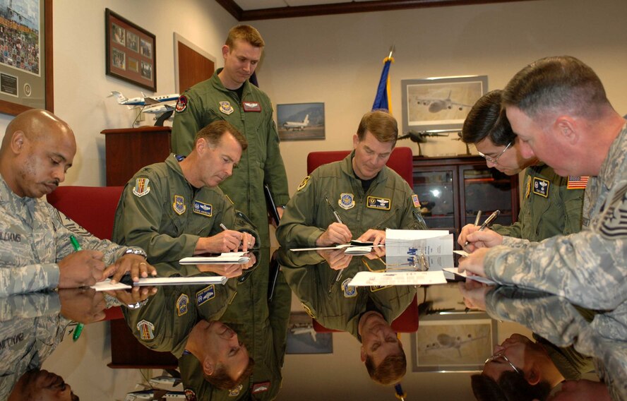 Travis leadership, (from left to right), Chief Master Sgt. Michael Williams, 60th Air Mobility Wing command chief, Col. Steve Arquiette, 60th AMW commander, Brig. Gen. Mark Stearns, 15th Expeditionary Mobility Task Force commander, Col. Tony Hinen, 615th Contingency Response Wing commander and Chief Master Sgt. Bruce Blodgett, 15th EMTF command chief, sign their pledges for the Air Force Assistance Fund March 10. The AFAF was established to provide an annual effort to raise funds for the charitable affiliates that provide support to the Air Force family (active duty, retirees, Reservists, Guard and their family members, including surviving spouses) in need. The campaign will run through April 21. (Air Force photo by Airman 1st Class Kristen Rohrer)