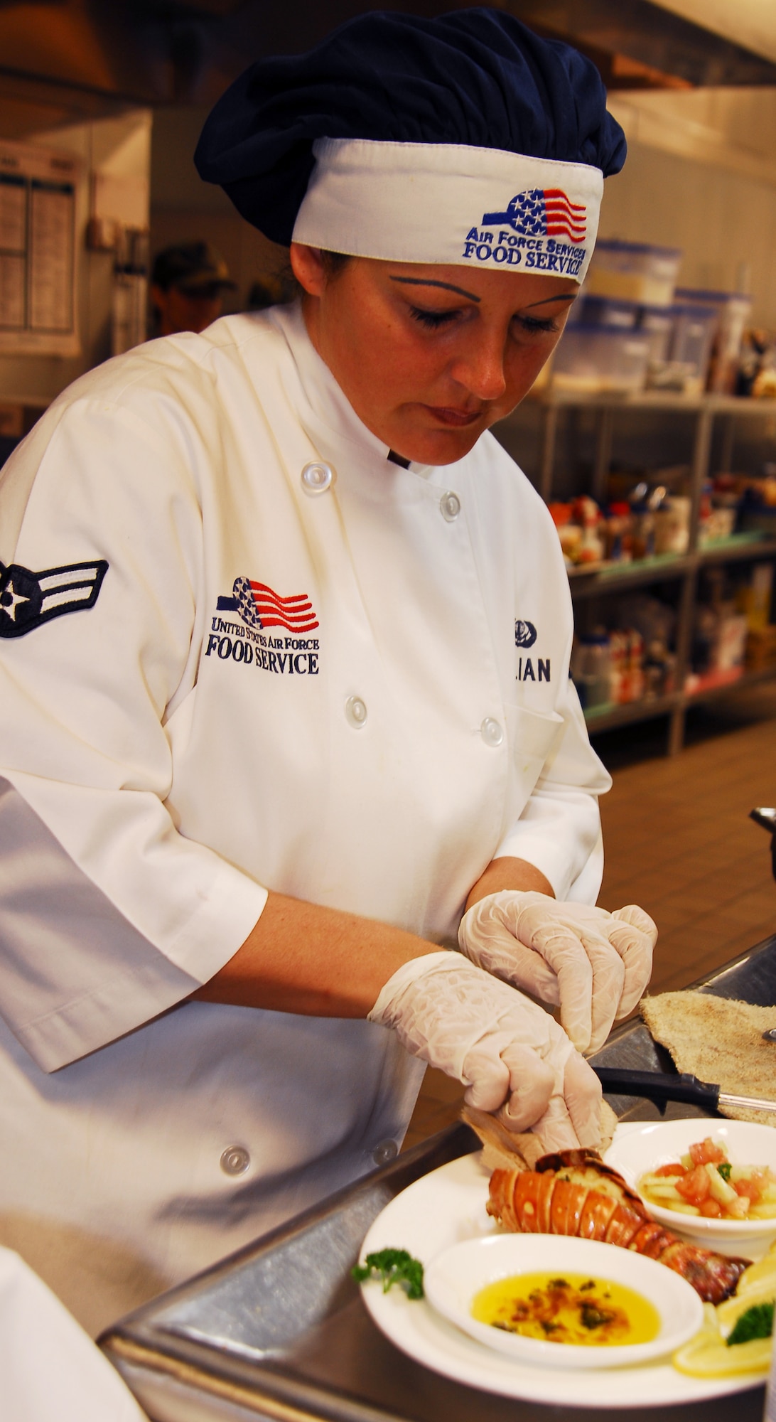 Airman 1st Class Katrin Julian, 1st Special Operations Services Squadron, puts the final touch on her boiled lobster entree during the Iron Chef competition March 10 at Hurlburt Field. Three Airmen, one from Eglin Air Force Base, one from Tyndall AFB and one from Hurlburt, participated in this inagural event where each chef prepared one dish for judging. The Airman from Tyndall AFB took first place in the event. (U.S. Air Force photo/Senior Airman Sheila deVera)