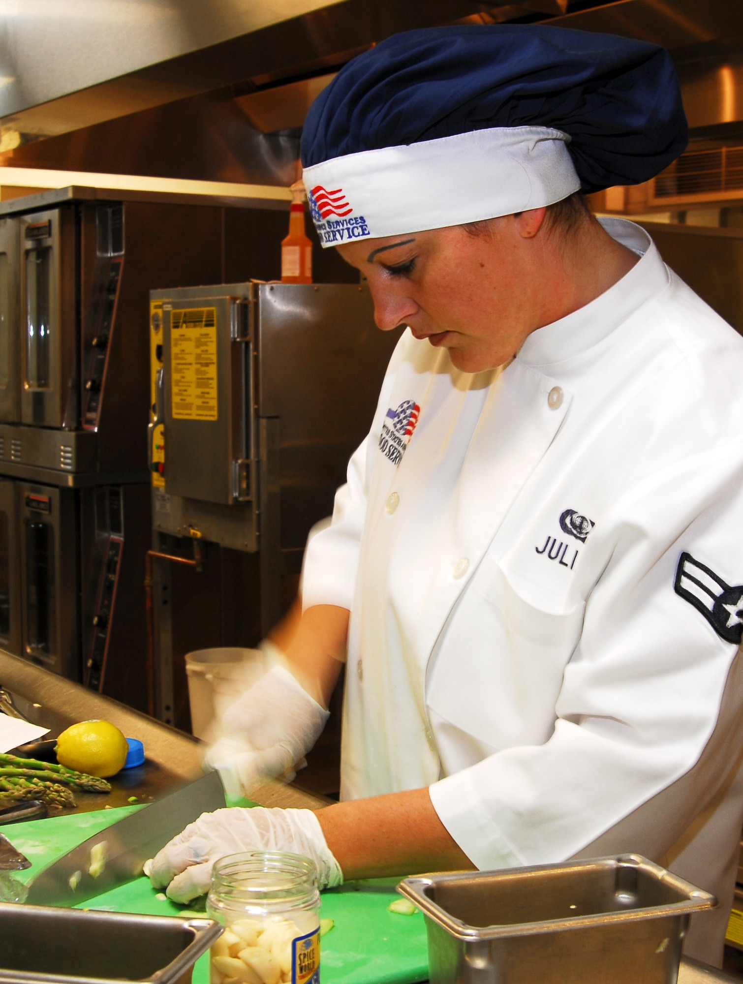 Airman 1st Class Katrin Julian, 1st Special Operations Services Squadron, cuts garlic cloves in preparation of her special dish during the Iron Chef competition March 10 at Hurlburt Field. Three Airmen, one from Eglin Air Force Base, one from Tyndall AFB and one from Hurlburt, participated in this inagural event where each chef prepared one dish for judging. The Airman from Tyndall AFB took first place in the event. (U.S. Air Force photo/Senior Airman Sheila deVera)