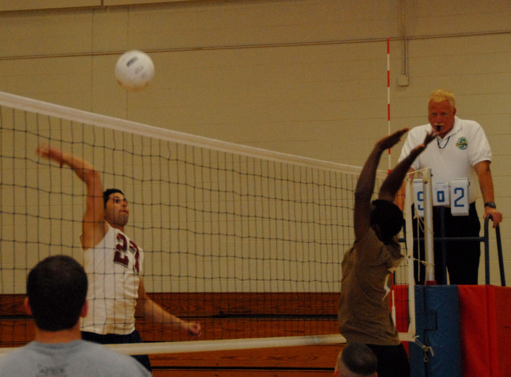The 53d Wing's Jose Mestey (left) jumps to spike the ball past the MedGroup Team 2's defenders during a intramural volleyball match at the base gym March 12.  The 53d won easily by more than 10 points in the two games.  The win moves the 53d team's record to 3-1 on the season.  Photo by Staff Sgt. Samuel King Jr.