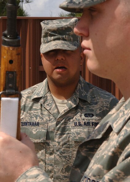 DYESS AIR FORCE BASE, Texas-- Airman 1st Class Ricardo Quintanar gives the command of port arms to Senior Airman Bryce Zabric during practice on March 10. Airman Quintanar is a member of the 7th Services Squadron and Airman Zabric is part of the 7th Aircraft Maintenance Squadron.(U.S Air Force photo by Airman 1st Class Felicia Juenke)