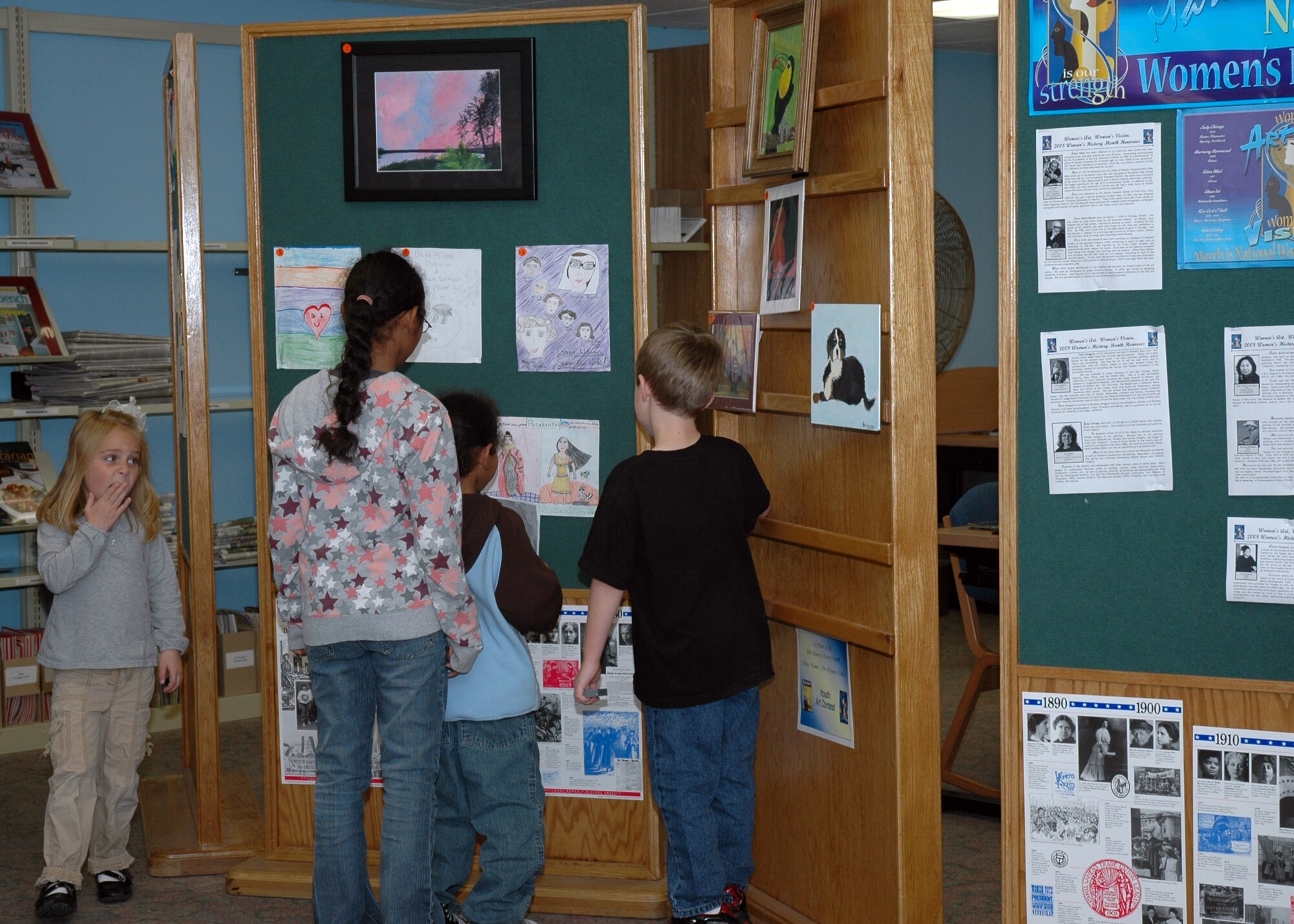 EGLIN AIR FORCE BASE, Fla. -- A group of children gathers at the base library March 11 to view the 48 entries in the Eglin Youth Art Contest. The contest was sponsored by the Women's History Month Committee because it related to the theme of the month, "Women's Art - Women's Vision." Three winners were chosen from three age categories. Joe Blankenberger was chosen in the age 7 and under category, Gabrielle Caggiano was chosen in the age 8 to 12 category and Amber Kaderbeck was chosen in the age 13 to 17 category. All 48 children who entered the contest recieved a certificate from the Women's History Month Committee. (U.S. Air Force photo by Staff Sgt. LuCelia Ball)