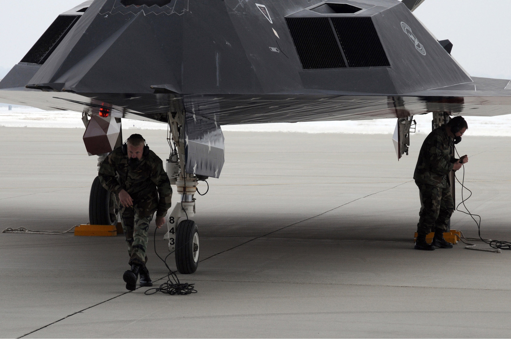 Crew members from the 49th Fighter Wing, Holloman Air Force Base, N.M. recieve an F-117 Nighthawk after its flyover during the Nighthawk farewell ceremony at Wright-Patterson Air Force Base, Ohio, March 11. (U.S. Air Force photo/Staff Sgt Joshua Strang) 