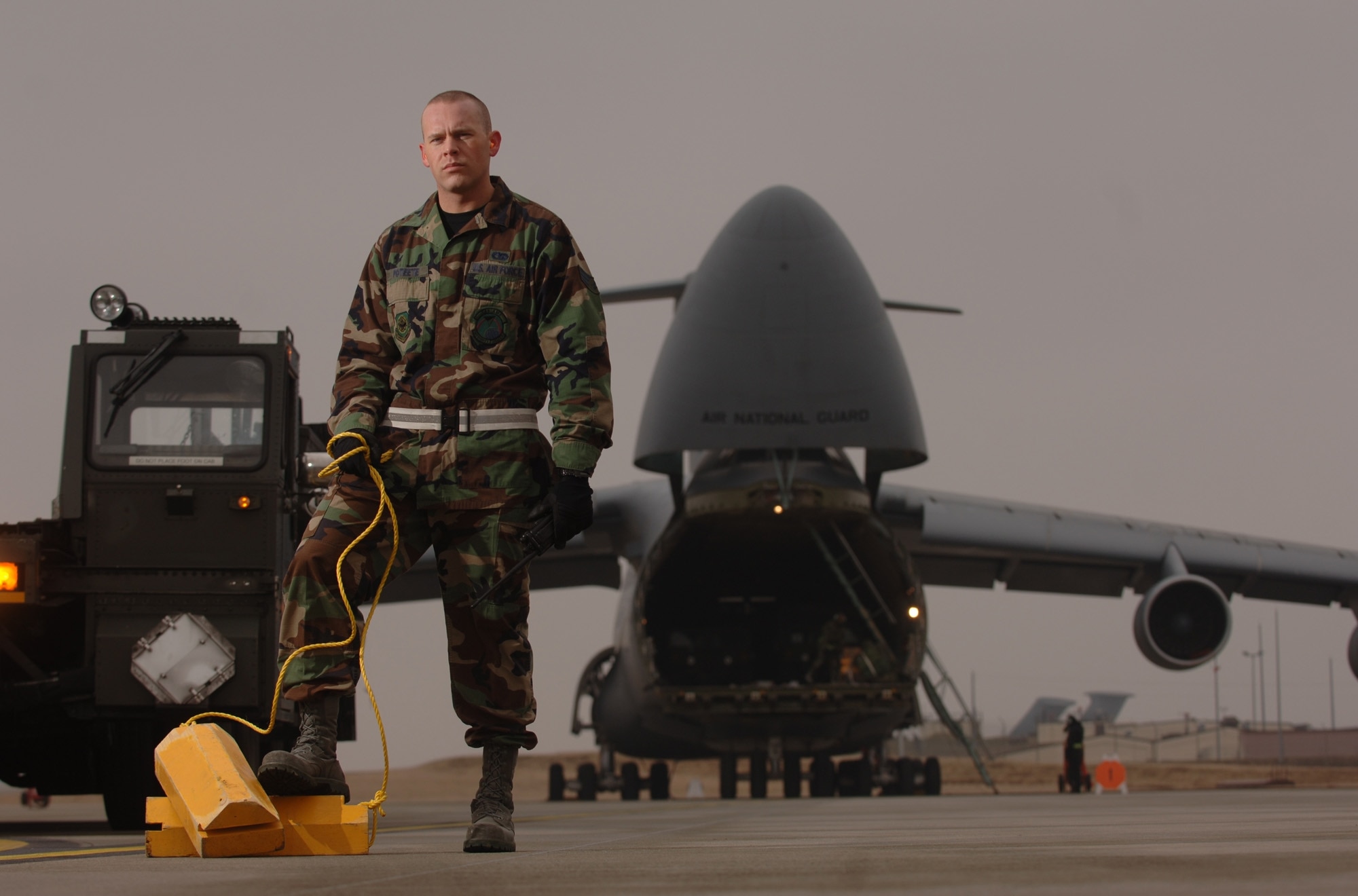 SPANGDAHLEM AIR BASE, Germany -- Air Transportation specialist, Senior Airman Jason Poteete and a 60K loader stand on the hot cargo pad here ready to service a C-5 Galaxy returning from down range with explosive cargo. Airman Poteete is assigned to the 726th Air Mobility Squadron. (U.S. Air Force photo/Master Sgt. Scott Wagers)
