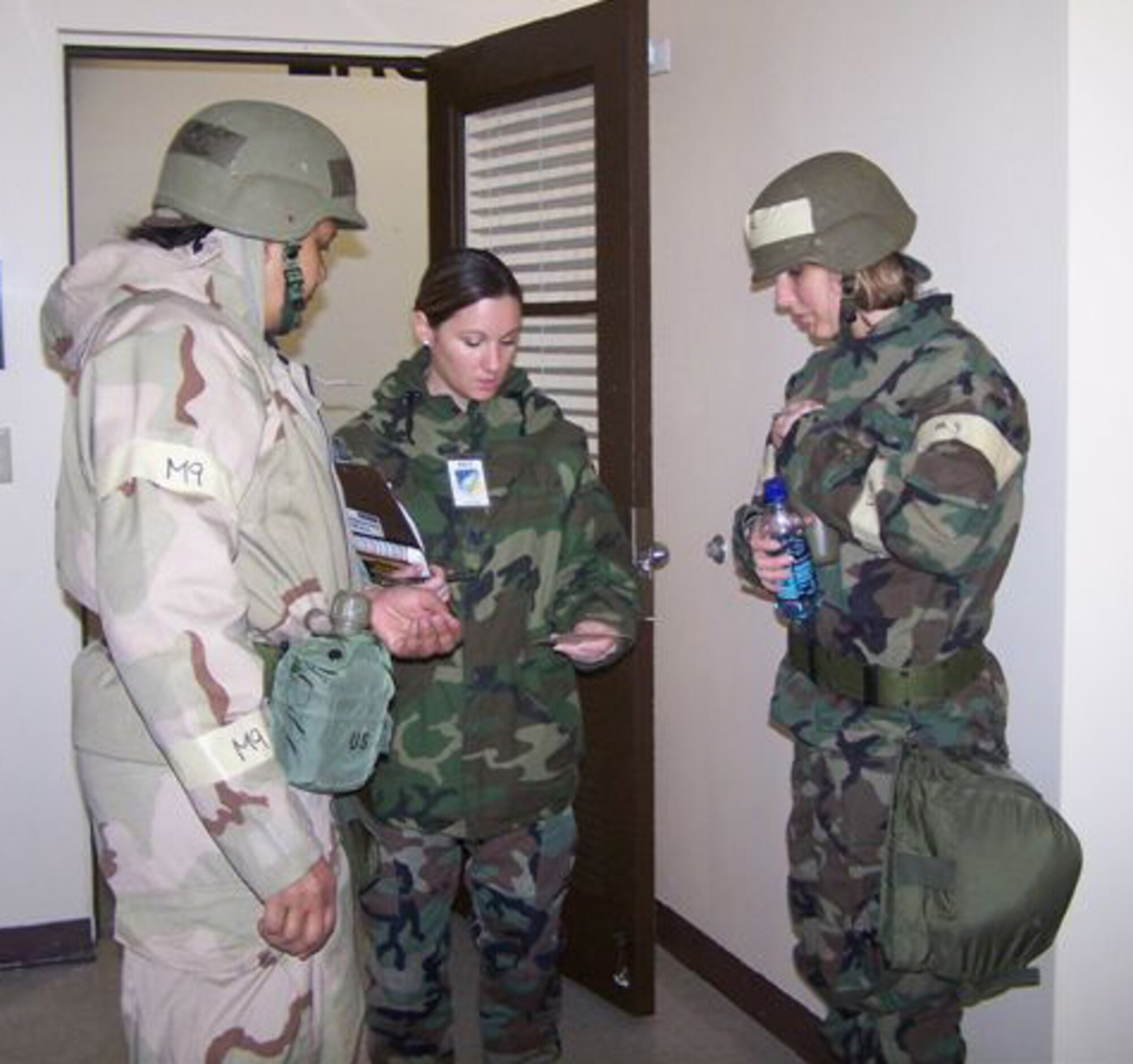 SEYMOUR JOHNSON AIR FORCE BASE, N.C. -- Tech. Sgt. Kelly Denger (middle) inspects the gas mask cards of Master Sgt. Benita Busch and Senior Airman Amanda Rodriguez during a mock exercise conducted by the 916th Air Refueling Wing. All three reservists belong to the 916th Logistics Readiness Squadron.