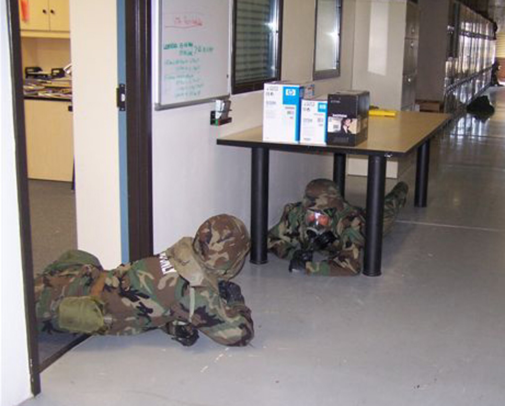SEYMOUR JOHNSON AIR FORCE BASE, N.C. -- Senior Master Sgt. Kevin Matteson and First Sergeant Robert Ewest demonstrate their ability to survive during a mock chemical attack conducted during the 916th Air Refueling Wing's March unit training assembly. Both sergeants are members of the 916th Logistics Readiness Squadron and were taking cover in their full chemical ensembles.
