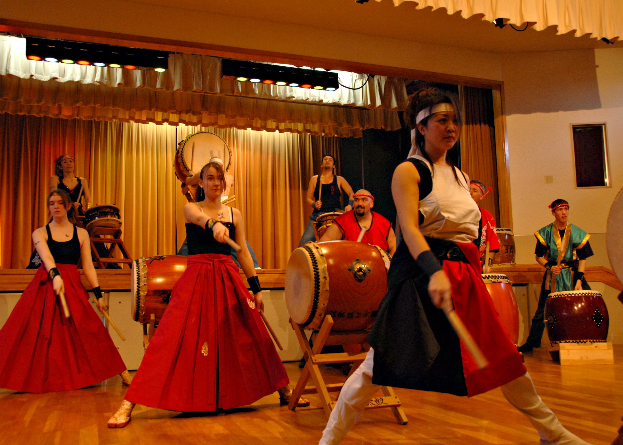 MISAWA AIR BASE, Japan -- Left to right, Eryn Duston, Stephanie Steele, both members of the Misawa Dragon-Eagle Taiko Team, perform with Naoko Echigoya, a member of the professional Kijinsyu Taiko Team. Performances with Americans are rare in professional Taiko due to the traditional views held by most Taiko teams that forbid foreign participation. (U.S. Air Force photo by Staff Sgt. Rachel Martinez)