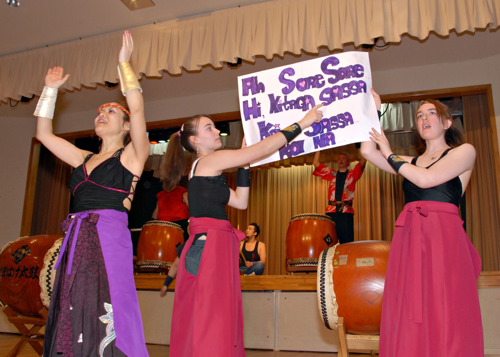 MISAWA AIR BASE, Japan -- Left to right, Kazuko Igarashi, Stephanie Steele and Eryn Duston, all members of Misawa's Dragon-Eagle Taiko Team, help the audience sing along to one of their songs. Audience participation is unique to this team, as most professional Taiko teams focus exclusively on stage performance. (U.S. Air Force photo by Staff Sgt. Rachel Martinez)