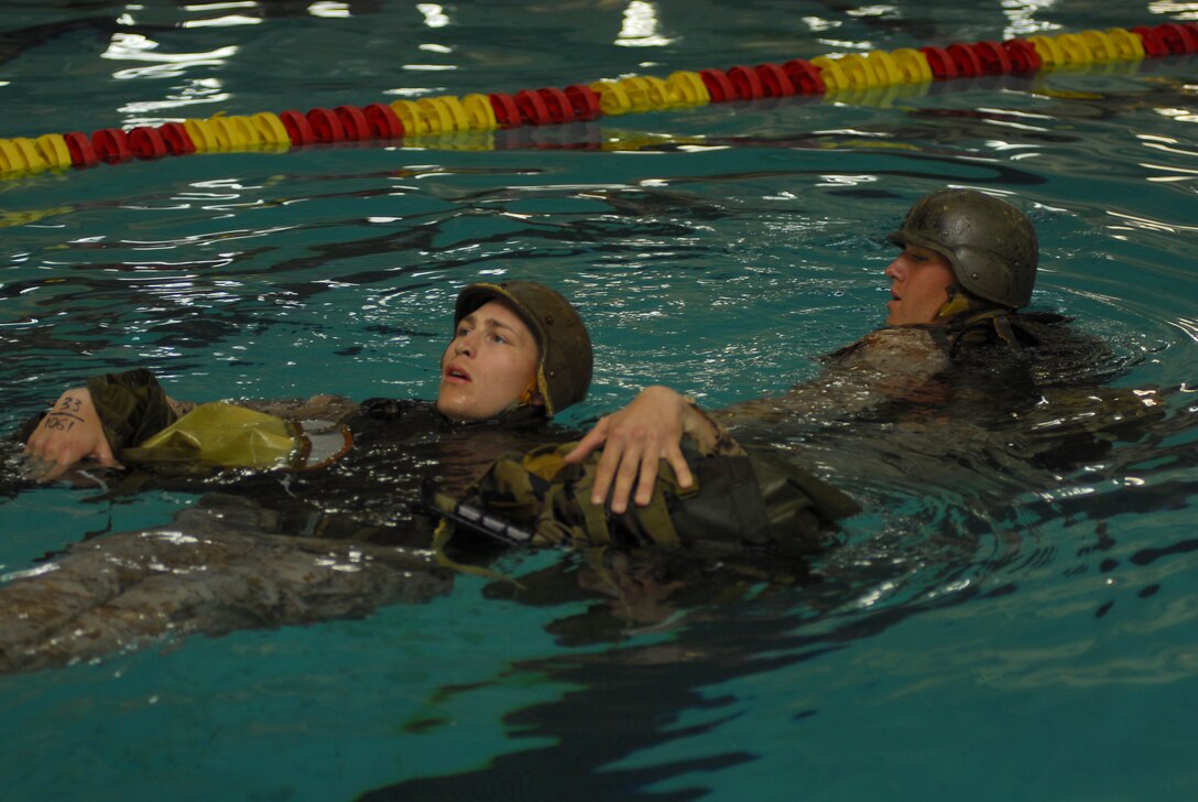 Recruit Russell Moore, right, Platoon 1065, Company D, tows Recruit Shane R. Fox, Platoon 1061, while attempting the second class swim qualification. Second class is focused on rescuing simulated exhausted or wounded Marines from battle.
