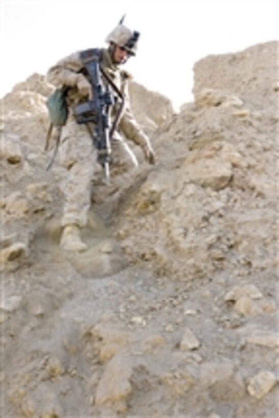 U.S. Marine Corps Pfc. Ryan Barber from 3rd Battalion, 4th Marine Regiment navigates down a steep slope during a patrol in Hit, Iraq, on March 7, 2008.  