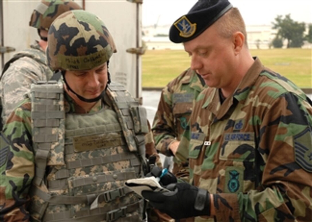 U.S. Air Force Master Sgt. Scott Elmblad, right, briefs Air Force Master Sgt. Keith Collins as part of the 2008 Pacific Air Forces operational readiness inspection on Kadena Air Base, Japan, March 11, 2008. Both men are assigned to the 18th Security Forces Squadron.