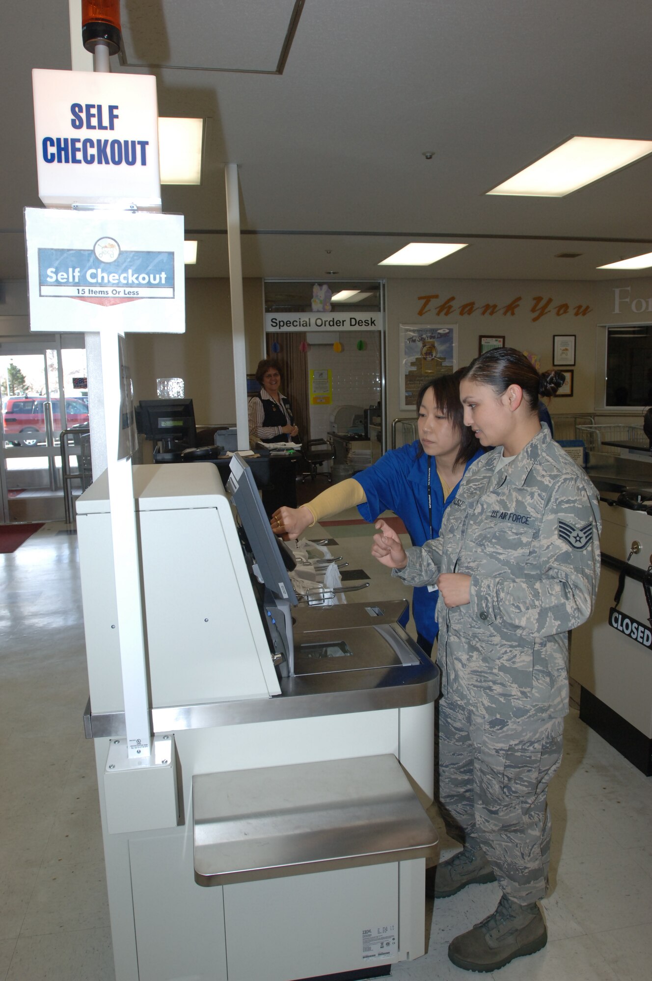 MISAWA AIR BASE, Japan -- Staff Sgt. Misty Delisle, 35th Fighter Wing Protocol, is shown how to use the new self-help check out machines at the base commissary Mar. 12, 2008. In addition to the self-checkout registers, the commissary has installed new state-of-the-art registers that will reduce the time customers wait in line. (U.S. Air Force photo by Senior Airman Robert Barnett)