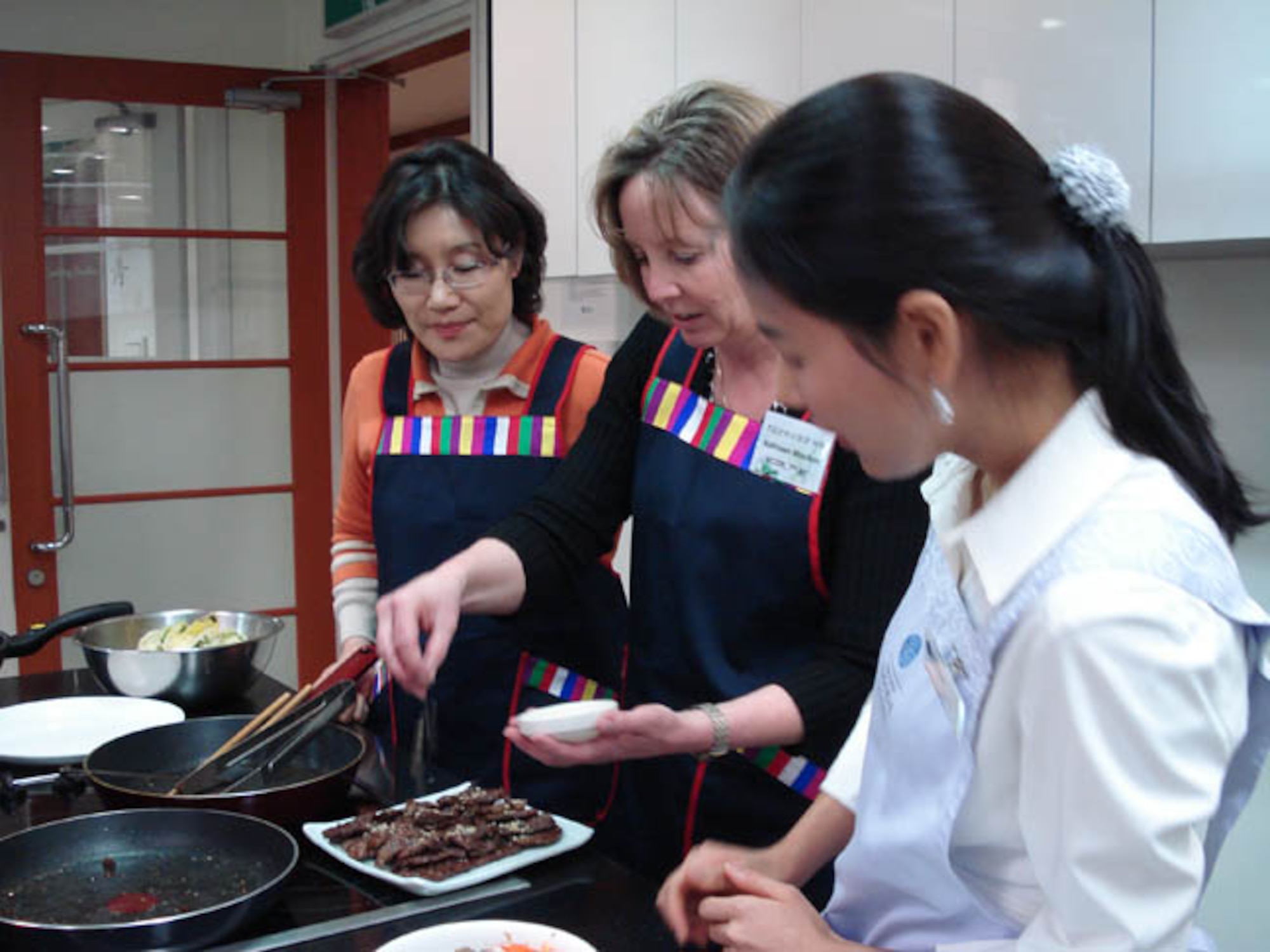 Mrs. Kathleen Moulton, wife of Brig. Gen. Harold Moulton, Seventh Air Forces and Air Forces Korea vice commander, garnishes the Nubiani she cooked with crushed pine nuts. 