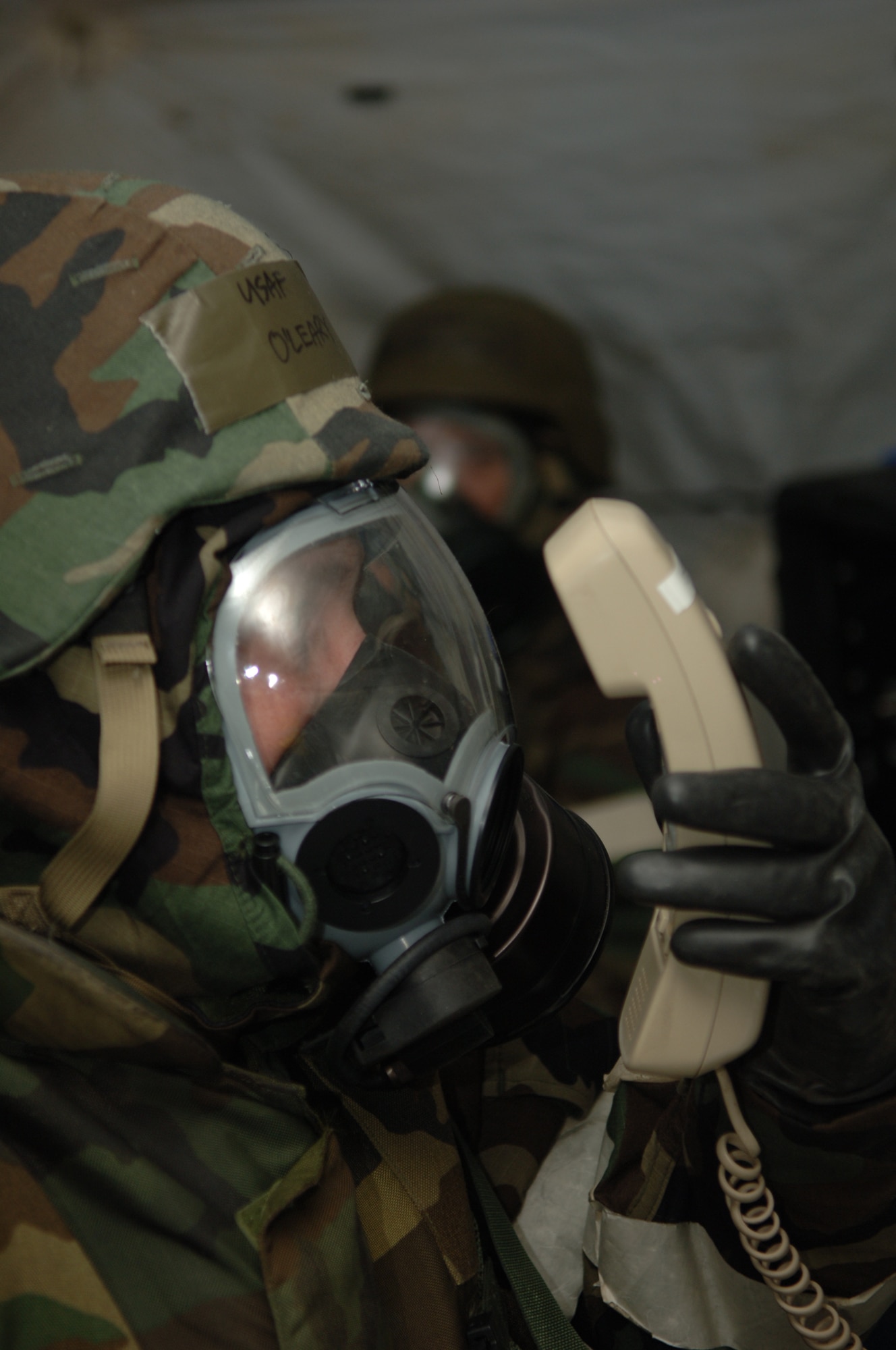 FAIRCHILD AIR FORCE BASE, Wash. – Master Sgt. Patrick O’Leary, 92nd Communication Squadron, speaks into the telephone while wearing his Mission Oriented Protective Posture (MOPP) level 4 gear during a local exercise here March 13. To prepare for real-world incidents, Airmen train to perform their mission-related tasks wearing full MOPP gear and under simulated attack. (U.S. Air Force photo/Senior Airman Jocelyn Ford)