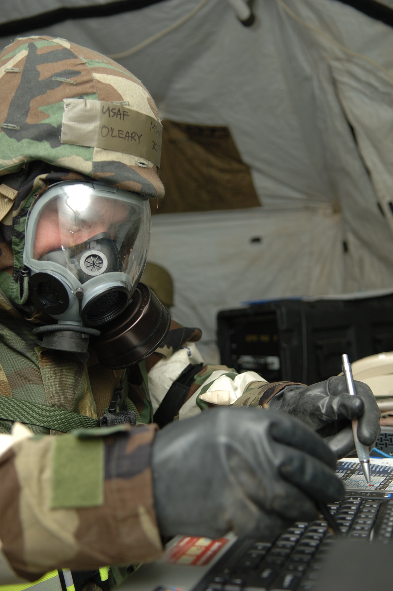 FAIRCHILD AIR FORCE BASE, Wash. – Master Sgt. Patrick O’Leary, 92nd Communication Squadron, utilizes pens to type on his keyboard while wearing protective gloves during a local exercise here March 13. Those gloves are part of Sergeant O’Leary’s Mission Oriented Protective Posture (MOPP) level 4 gear, which he wears after a simulated chemical attack. (U.S. Air Force photo/Senior Airman Jocelyn Ford)