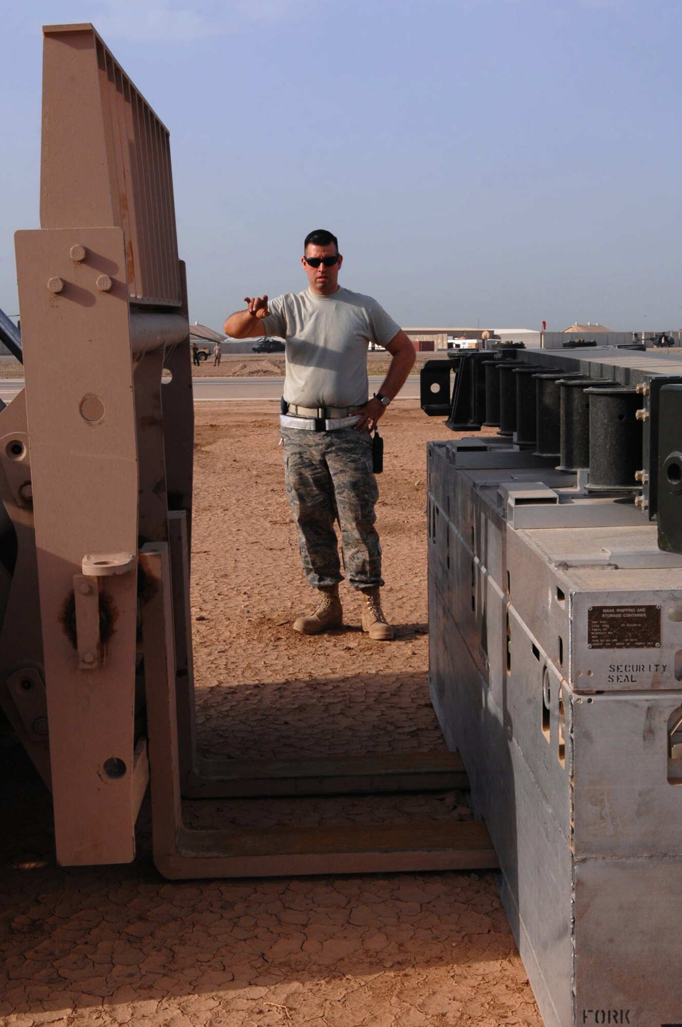 Tech. Sgt. Emmanuel Ramirez guides a forklift to pick up a new arresting barrier system March 12 at Balad Air Base, Iraq. An ABS is a cable stretched across the runway; pilots drop a hook from the back of fighter aircraft and catch it during emergency landings. Sergeant Ramirez is a 332nd Expeditionary Civil Engineer Squadron power production technician deployed form Peterson Air Force Base, Colo. (U.S. Air Force photo/Senior Airman Julianne Showalter) 