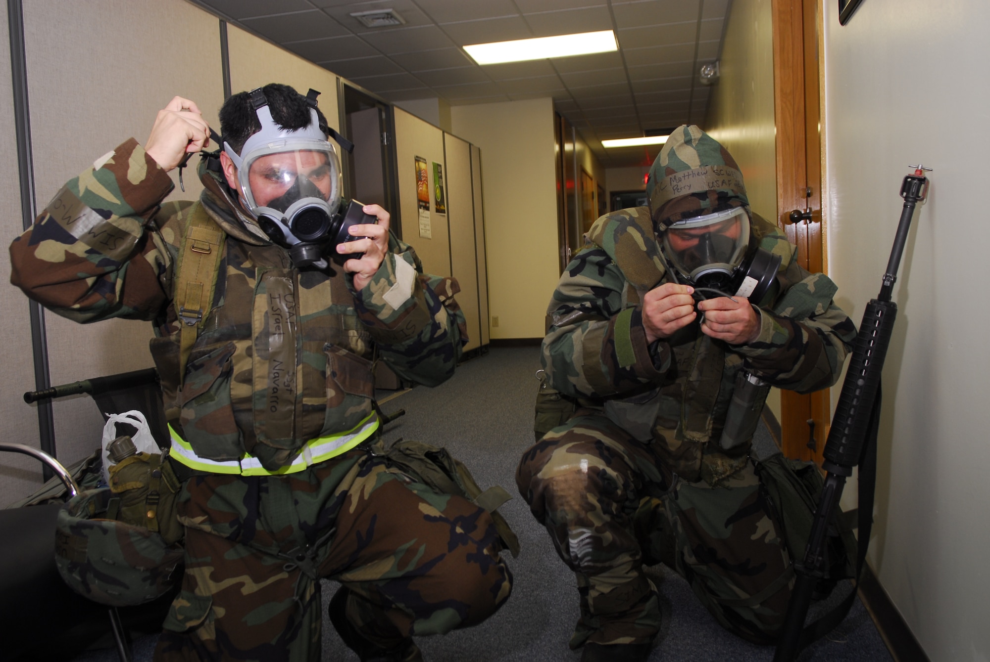 Staff Sgt. Israel Navarro and Airman 1st Class Matthew Perry, from the 18th Communications Squadron, don their gas masks during the 2008 Pacific Air Forces Operational Readiness Inspection at Kadena Air Base, Japan, March 13, 2008. PACAF conducted the inspection from March 9 to 15 to validate mission readiness of the 18th Wing. (U.S. Air Force photo/Staff Sgt. Joshua J. Garcia) 
