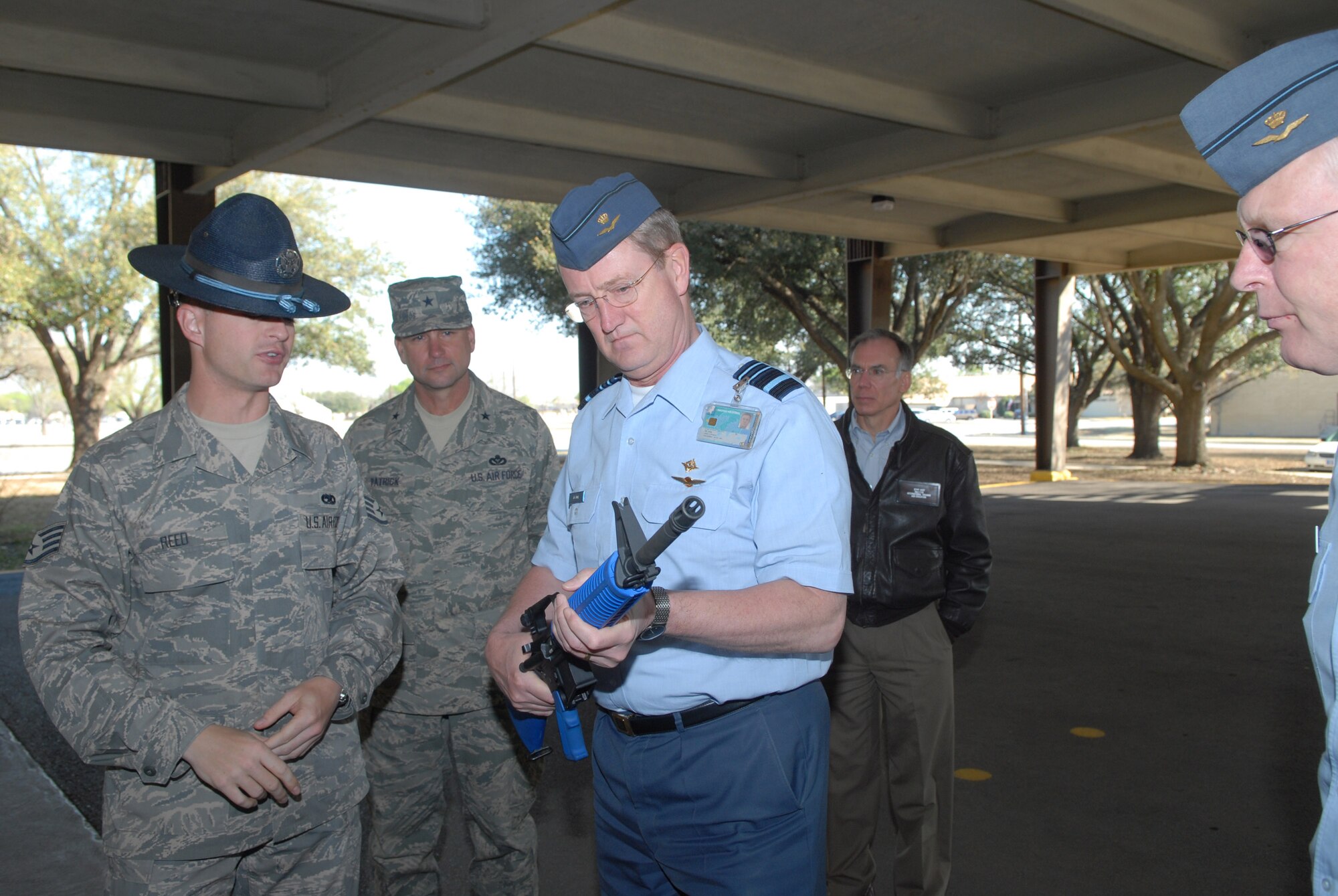 Staff Sgt. Daniel Reed shows Lt. Gen. Hans de Jong the blue M-16 rifles trainees carry throughout their basic training during the general's tour March 11 of Lackland Air Force Base, Texas. General Jong is the Royal Netherlands air force commander. Sergeant Reed is a military training instructor from the 324th Training Squadron at Lackland AFB. (U.S. Air Force photo/Richard McFadden)