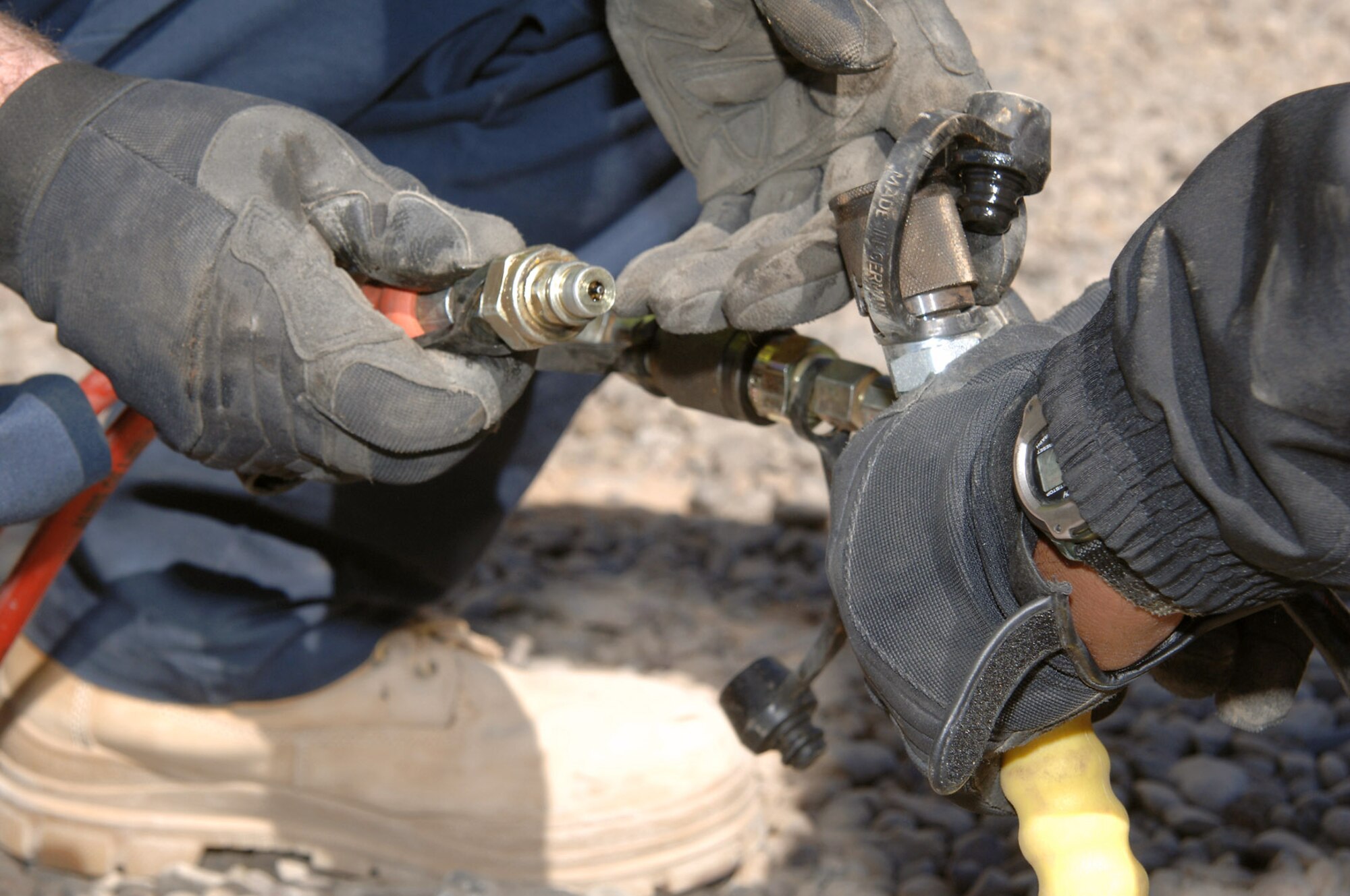 Senior mechanic contractors who work for KBR Theater Transportation Mission Recovery secure a hydraulic line to a tool during a refresher training session on using Jaws of Life-type tools March 5 at Balad Air Base, Iraq. The class was led by Airmen assigned to the 332nd Expeditionary Civil Engineer Squadron Fire Department. The senior mechanics are responsible for retrieving stuck, broken down and destroyed military vehicles throughout Iraq. (U.S. Air Force photo/Master Sgt. Heather Cabral) 
