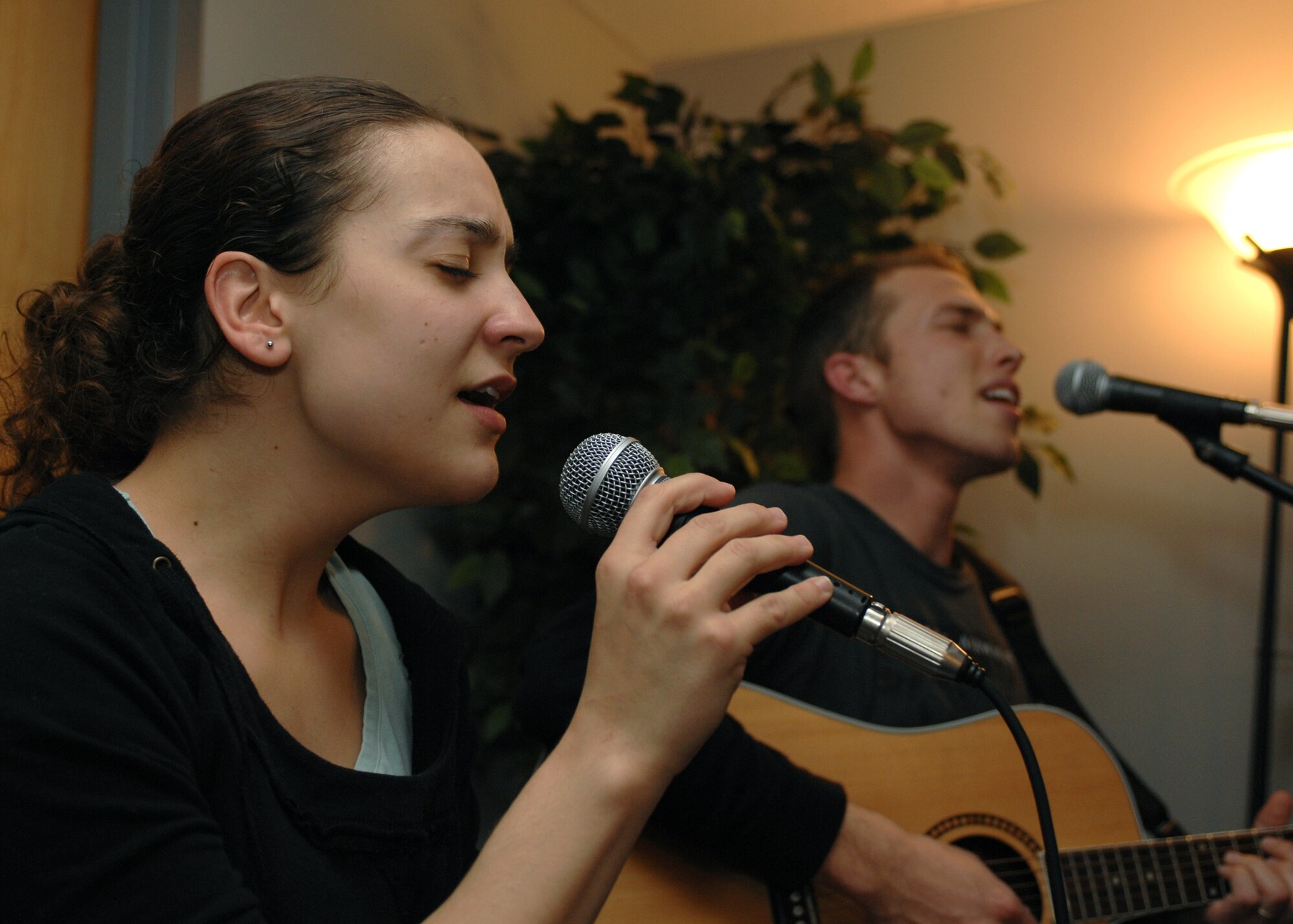 LANGLEY AIR FORCE BASE, Va. -- Valerie Becker and Airman 1st Class Bradley Pfister, 1st Equipment Maintenance Squadron stockpile surveillance technician, sing a duet during Open Mic Night at the Eagle's Wing March 7. Ms. Becker is the wife of Senior Airman Thomas Becker, 1st Civil Engineer Squadron explosive ordnance disposal journeyman. The Eagle’s Wing has an Open Mic Night the first Friday of each month. For more information on the Eagle’s Wing, call Mr. Rich Roberts at 764-6726. (U.S. Air Force photo/Airman Rebecca Montez)