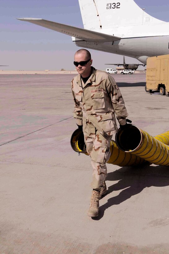 Staff Sgt. James A. Mellon removes hoses from an RC-135 Rivet Joint March 12 at a Southwest Asia air base. Aircraft hoses are used to keep the inside of the aircraft cool. Sergeant Mellon, assigned to the 379th Expeditionary Reconnaissance Squadron, is deployed from Offutt Air Force Base, Neb. (U.S. Air Force photo/Tech. Sgt. Johnny L. Saldivar) 