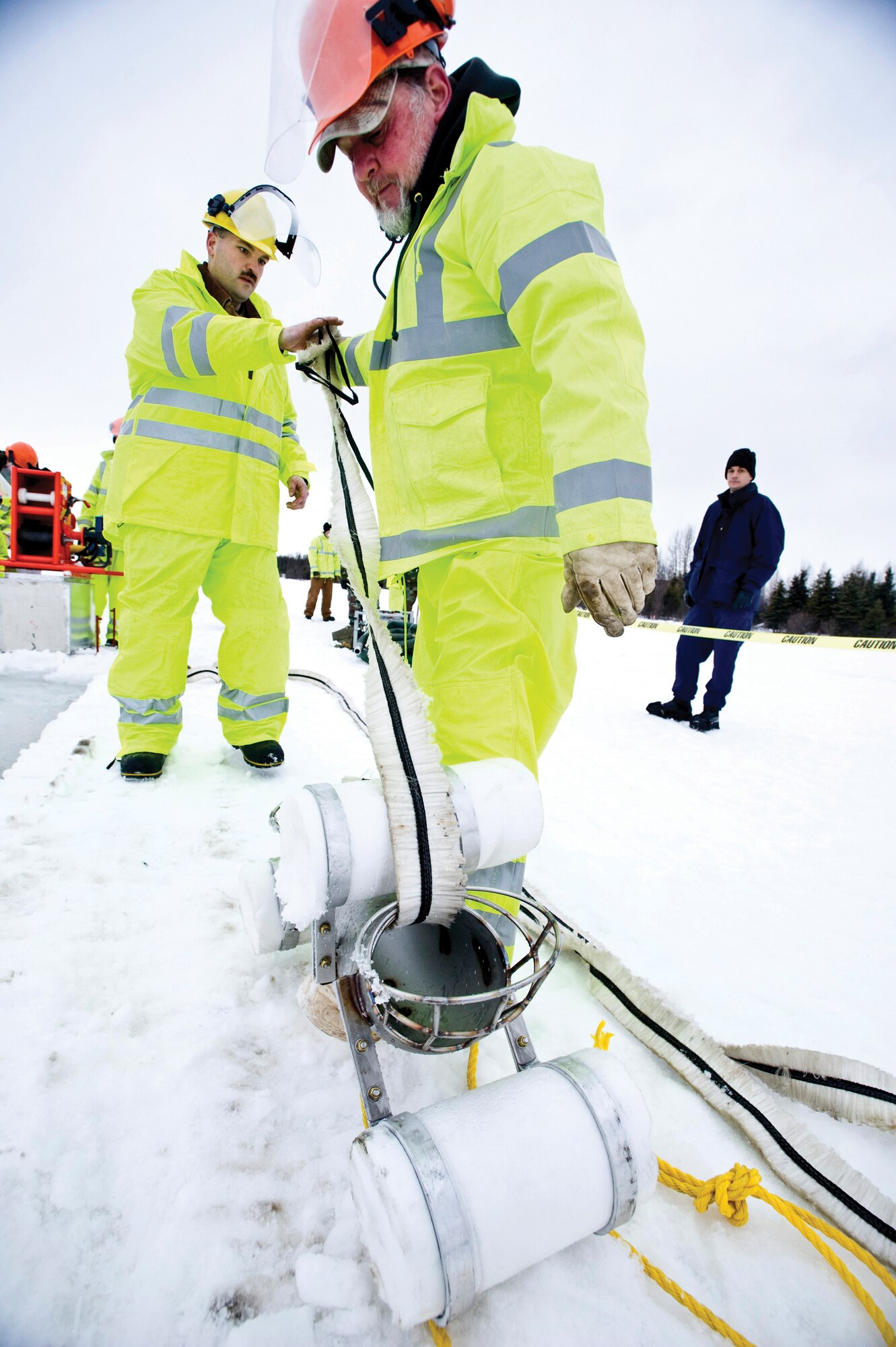 ELMENDORF AIR FORCE BASE, Alaska ? Harry Goslin and Tech. Sgt. Tim Lewallen, 611th Civil Engineer Squadron, pull the rope mop through a pulley here March 4. The rope mop is used to collect oil spills from the water. (U.S. Air Force photo by Airman 1st Class Jonathan Steffen)