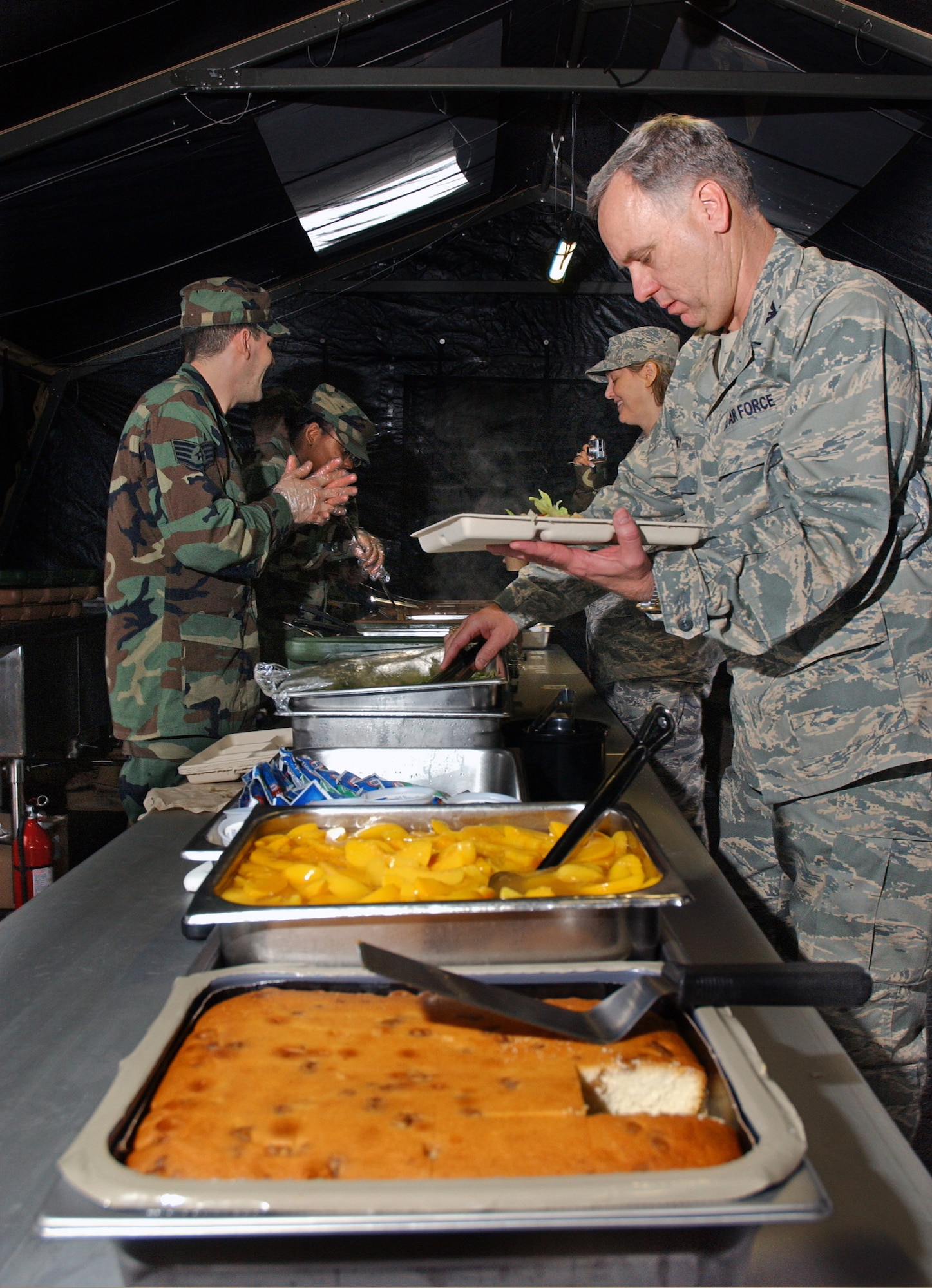 Col. Clifton Perry chooses from a variety of food offered by the 18th Services Squadron single pallet expeditionary kitchen during the Pacific Air Forces Operational Readiness Inspection March 11at Kadena Air Base, Japan. The deployable kitchen can be set up from pallet to serving in under four hours. PACAF is conducting the inspection from March 9 to 15 to validate the mission readiness of the 18th Wing. Colonel Perry is the 18th Wing chaplain. (U.S. Air Force photo/Senior Airman Jeremy McGuffin) 
