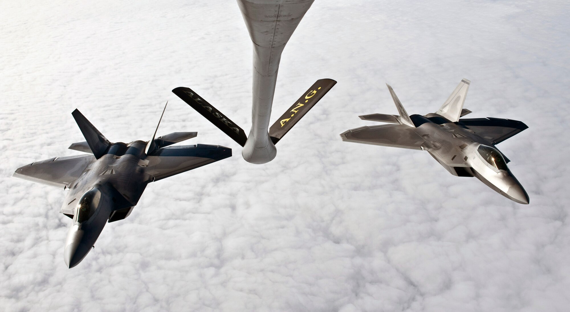 OVER ALASKA -- A KC-135 Stratotanker from the Alaska Air National Guard 168th Air Refueling Wing waits as two F-22 Raptors from the 90th Fighter Squadron at Elmendorf Air Force Base fly in for refueling. With the KC-135's mission of air refueling, the F-22 capabilities can accomplish its mission of global engagement. (U.S. Air Force photo by Airman 1st Class Jonathan Steffen)