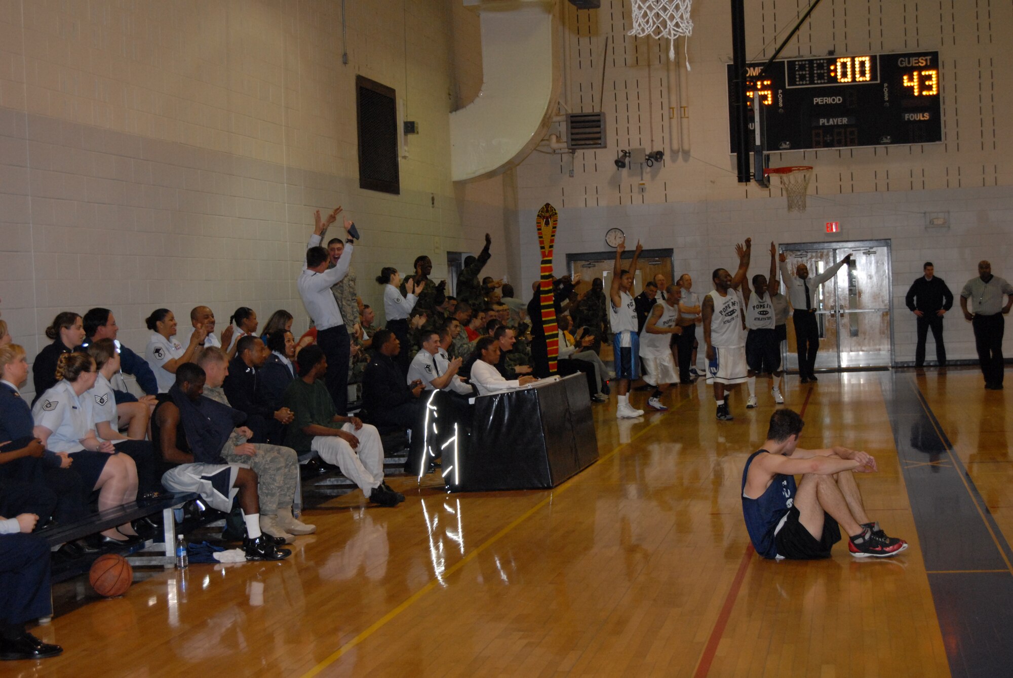 The 43rd Logistics Readiness Squadron celebrates their victory as time runs out in the Pope Intramural Basketball Championship March 3, while Jared Bourgeois, 43rd Mission Support Squadron, looks on. 43rd LRS defeated 43rd MSS 55-43 to win their second consecutive championship. (U.S. Air Force Photo/2nd Lt. Chris Hoyler)