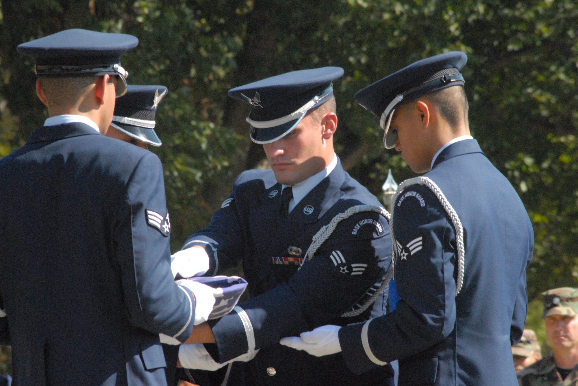 (Left to right) Senior Airman Cevan Epps, Joint Special Operations Command, Senior Airman Tracy Rectenwald, 43rd Maintenance Squadron, Senior Airman Marc Rodrigues, 43rd Comptroller Squadron, and Senior Airman Aldwin Del Rosario, 43rd Logistics Readiness Squadron, fold the flag during a Wing Retreat ceremony in September 2007. They were members of Pope’s Honor Guard, the AMC Honor Guard of the Year. (U.S. Air Force Photo/Airman 1st Class Mindy Bloem)
