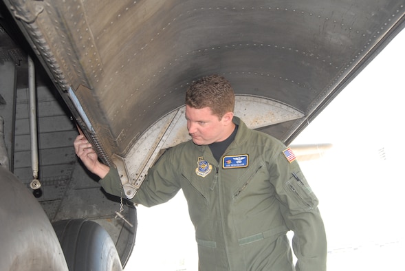 Staff Sgt. Brian McCraw, 2nd Airlift Squadron, checks the rear landing gear of a C-130E model on the flightline Tuesday. Sergeant McGraw recently returned from a deployment to Southwest Asia. (U.S. Air Force Photo/Airman 1st Class Mindy Bloem)
