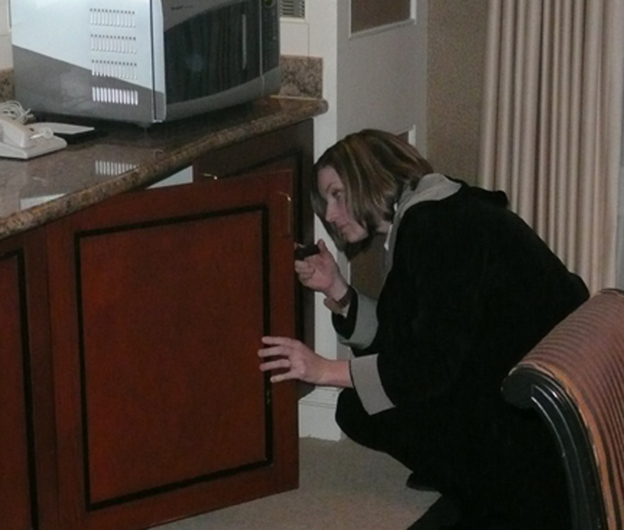 An Air Force Office of Special Investigations Agent conducts a thorough room search before an arrival of high profile (VIP) personnel under federal protection. (courtesy photo) 