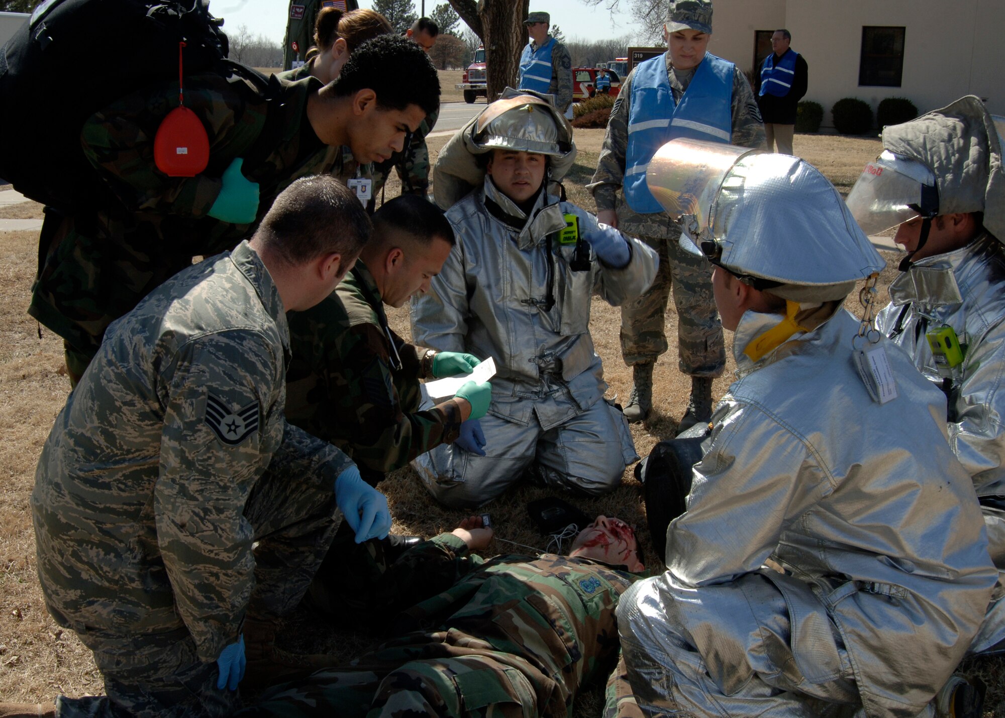 MCCONNELL AIR FORCE BASE, Kan. -- Emergency first responders from the base clinic and fire department respond to mock injury victim, Master Sgt. Robert Reader, 22nd Security Forces Squadron, during a base wide tornado response exercise, March 11. During the exercise, McConnell's exercise evaluation team primarily assessed the effectiveness of the base's emergency notification systems. (photo by Airman Justin Shelton)