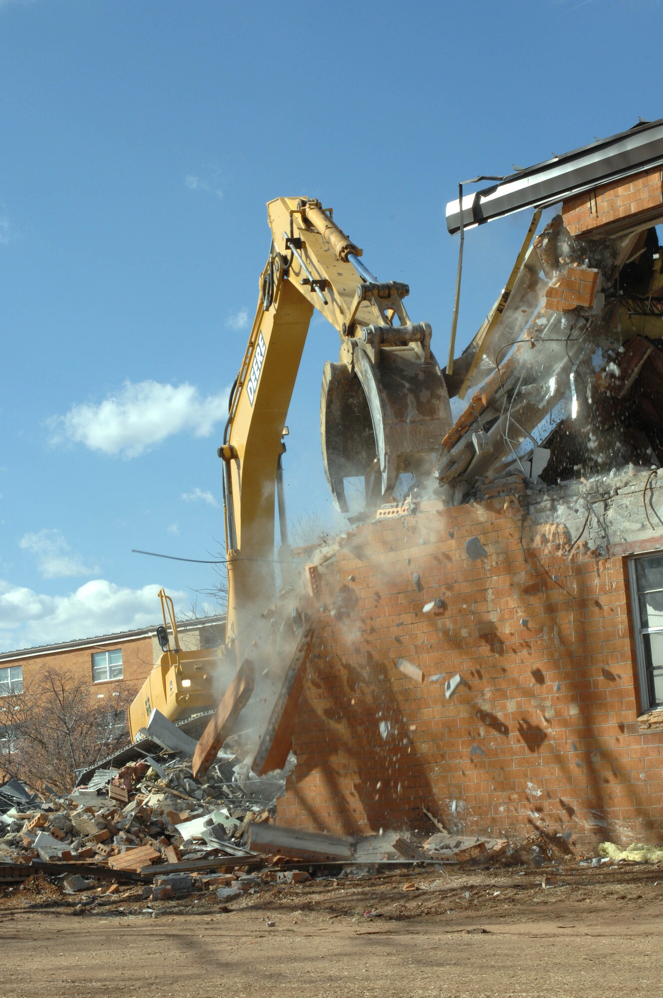 CANNON AIR FORCE BASE, N.M. - Dorm 1247 gets a chunk taken out of it March 11 to make way for the construction of a new dining facility/Airmen's center. The old post office and Dorm 1247 are currently being demolished to make way for the new facility and its parking lot. (U.S. Air Force photo by Airman 1st Class James Bell)