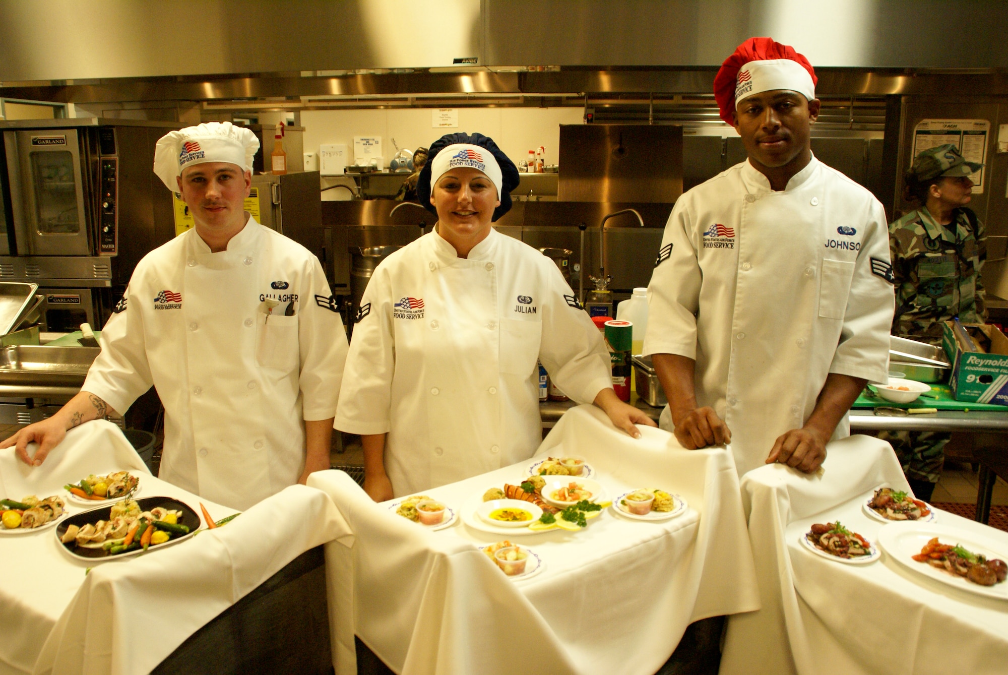 (Left to Right) Airmen First Class  Christian Gallagher and Katrin Julian, and Senior Airman Brandon Johnson with their finished entries in the Top Chef competition.
                 