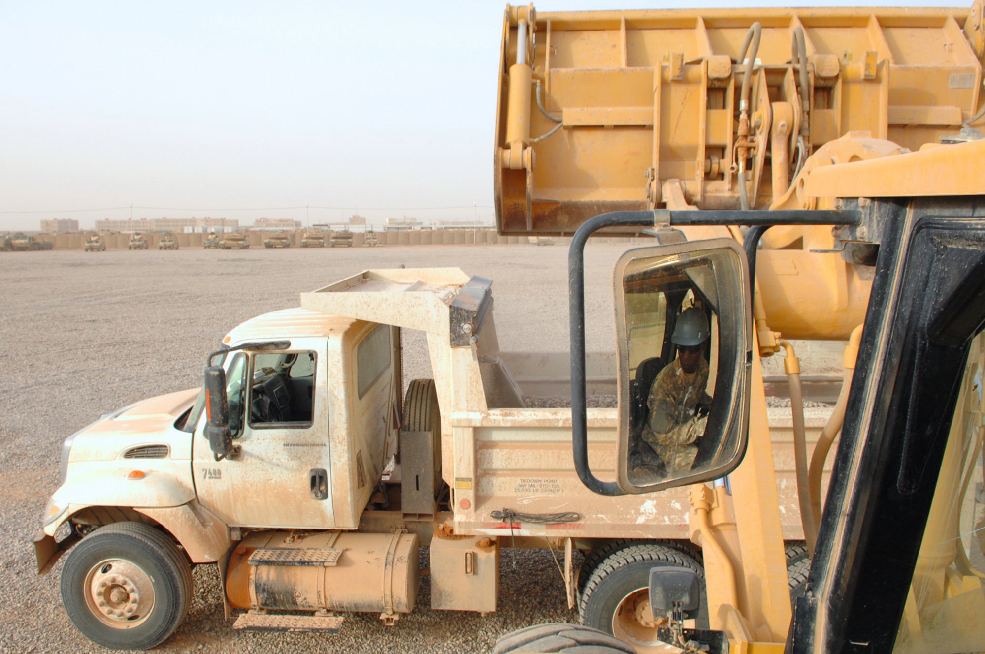 FORWARD OPERATING BASE CALDWELL, Iraq -- Tech. Sgt. Delbert Johnson assigned to the 732nd Expeditionary Civil Engineer Squadron Detachment 6, operates a front loader dumping gravel into a dump truck to be dispersed across the new maintenance yard here, March 3. The Detachment 6 Airmen built the maintenance yard for the U.S. Army to safely house tactical vehicles. (U.S. Air Force photo/ Senior Airman Julianne Showalter)