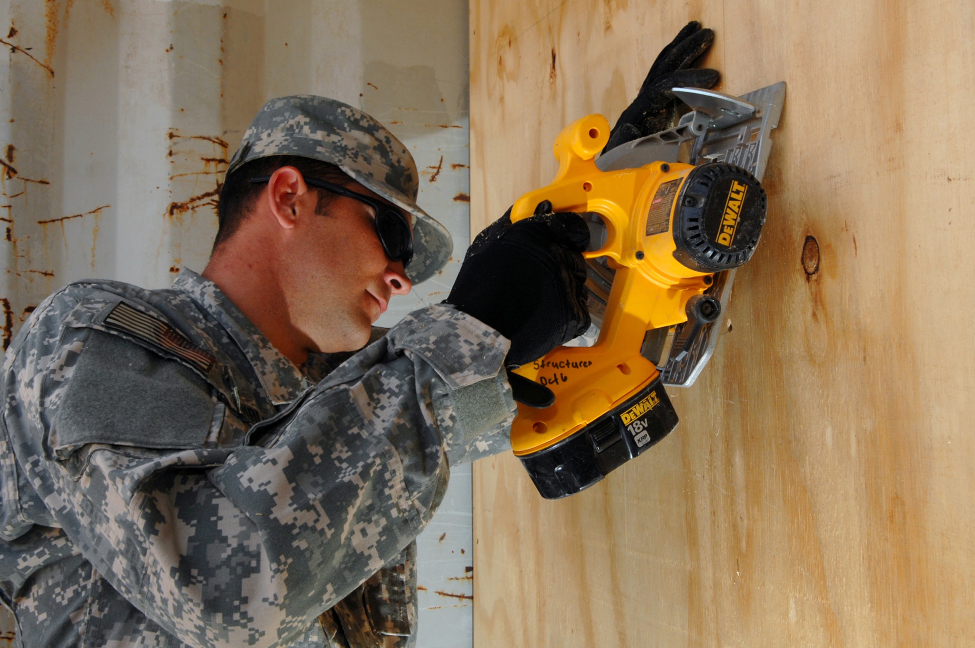 FORWARD OPERATING BASE NORMANDY, Iraq -- Airman 1st Class Bradley Hambleton, 732nd Expeditionary Civil Engineer Squadron Detachment 6 cuts out a space for an air conditioning unit to be installed into a portable living quarter unit here, March 2. The units house four servicemembers and are equipped with heating and air conditioning. (U.S. Air Force photo/ Senior Airman Julianne Showalter)