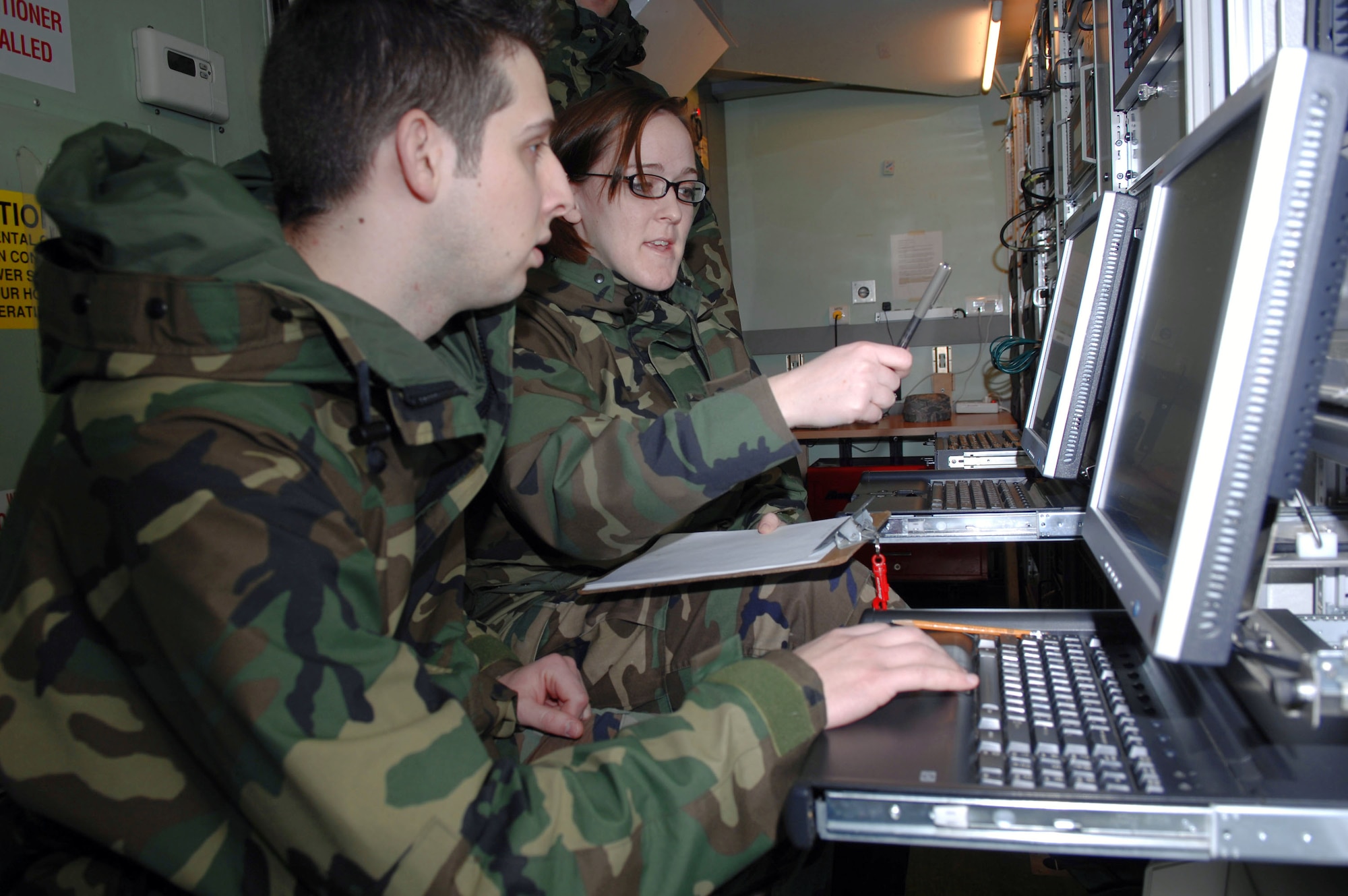 Staff Sgt. Susanne Dehne teaches Airman 1st Class Mike Frimel how to program the Eagle Vision-1 antenna's pass plan to view various commercial satellites in order to download images of areas of interest Feb. 29 at Ramstein Air Base, Germany. Sergeant Dehne is a commercial satellite imagery collections manager and Airman Frimel is  ground station controller. (U.S. Air Force photo/Senior Master Sgt. Hollis Dawson) 