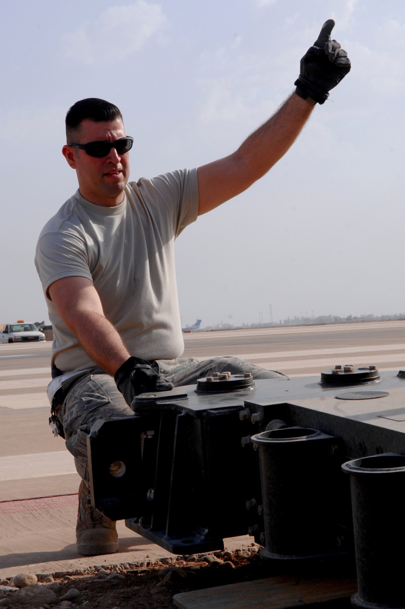 BALAD AIR BASE, Iraq -- Tech. Sgt. Emmanuel Ramirez, 332nd Expeditionary Civil Engineer Squadron power production technician, guides a forklift to place an arresting barrier system on the runway here, March 12. The system is composed of a cable stretched out across the runway attached to a braking system that brings fighter aircraft to a smooth halt during emergency landings. Sergeant Ramirez is deployed form Peterson Air Force Base, Colo. (U.S. Air Force photo/ Senior Airman Julianne Showalter)