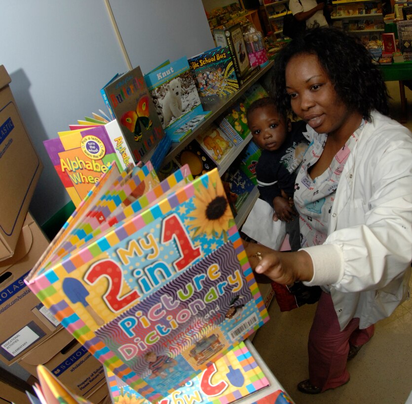 Ms. Temi Akinpetide, a Malcolm Grow Nurse, looks with her son Femmy, 6-12 month room at Child Development Center 2 (CDC2), at a 2 in 1 Picture Dictionary at the Book Fair held at CDC2 on 04 March 2008 in Andrews AFB, MD. 
(USAF Photo taken by Senior Airman Melissa Stonecipher)
