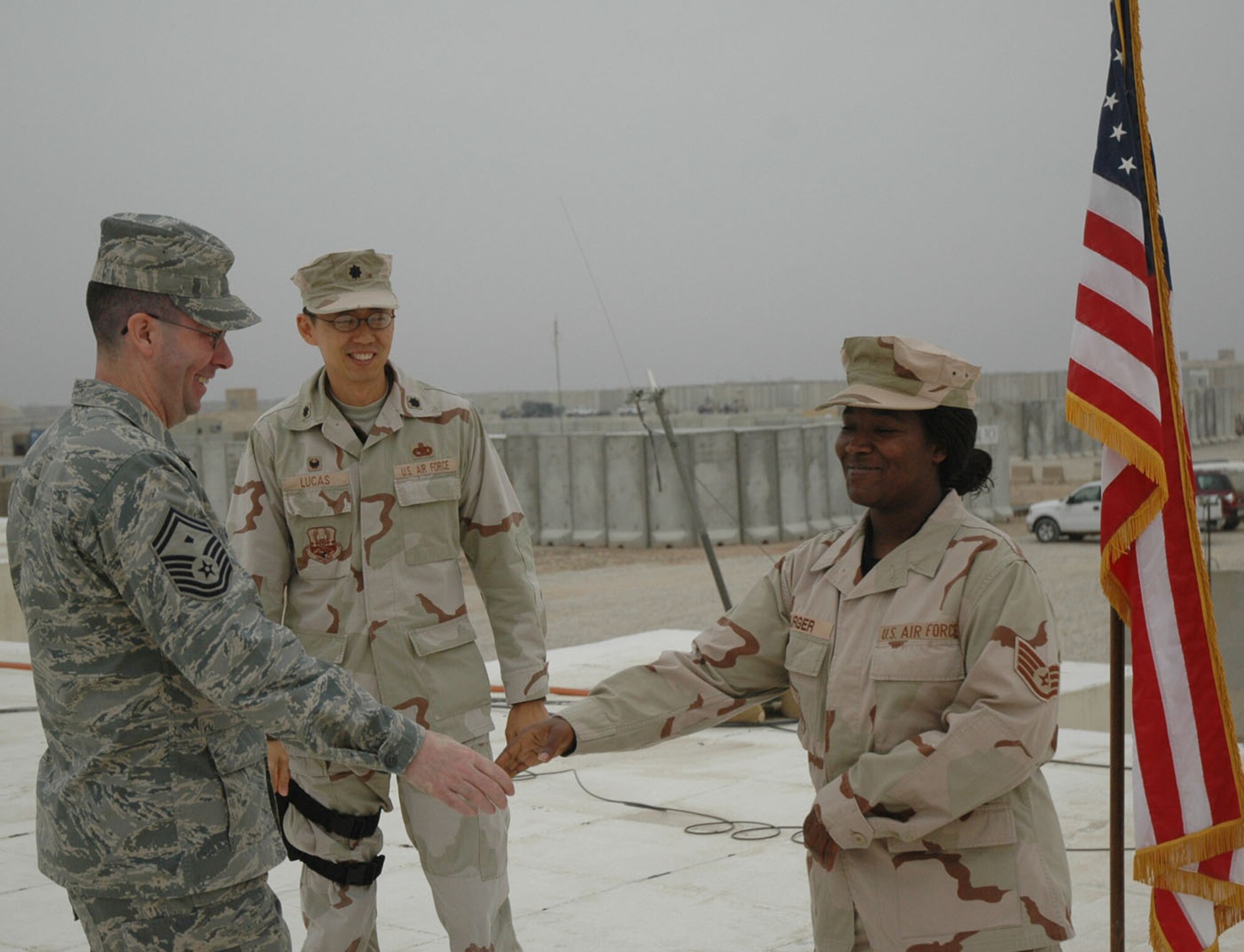 Senior Master Sgt. Richard Coyle, 100th Mission Support Squadron first sergeant, congratulates an Air Force member on her reenlistment during a deployment in Iraq. Sergeant Coyle is the 100th Air Refueling Wing's First Sergeant of the Year, 2007. (Courtesy photo)