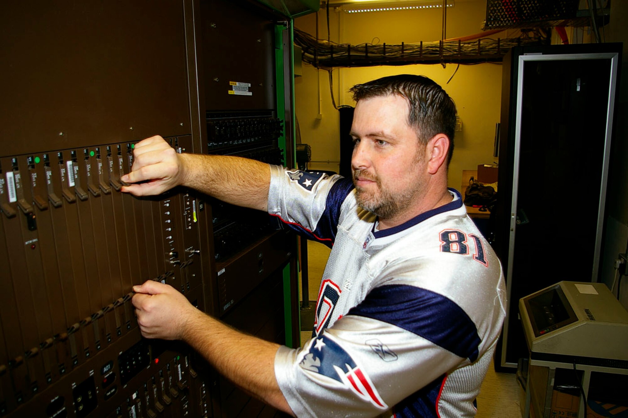 Dean Burson, 100th Communications Squadron Operations Flight, simulates changing cards on the digital multiplexing system 100. This equipment provides the dial tone for all on-base phones. Mr. Burson recently won the 100th Air Refueling Wing's Civilian Supervisor Award for 2007. (U.S. Air Force photo by Karen Abeyasekere)