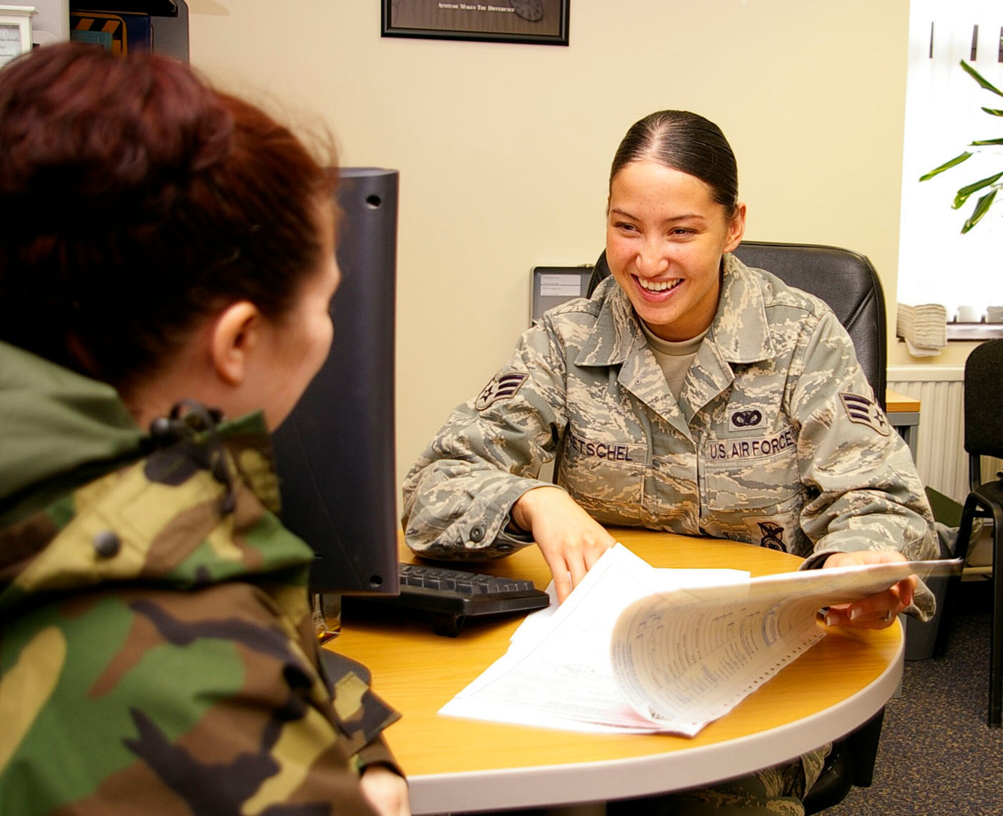 Senior Airman Alicia Goetschel (formerly Ewing), right, helps a customer fill out a road tax application for renewal of road tax. Airman Goetschel earned the 100th Air Refueling Wing's annual award, Airman Category, for 2007. (U.S. Air Force photo by Karen Abeyasekere)