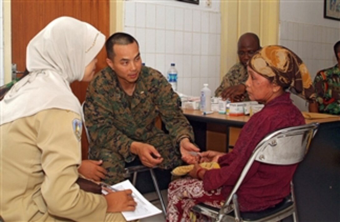 U.S. Navy Lt. Thomas Hoang (2nd from left) speaks with a patient during a medical and dental civic action project in Puskesmas Jangkar, Indonesia, on March 12, 2008.  U.S. Marines and sailors from the 31st Marine Expeditionary Unit and members of the Indonesian armed forces are conducting the project to increase humanitarian assistance and disaster relief response capabilities, improve interoperability and continue professional relationships between the two militaries.  