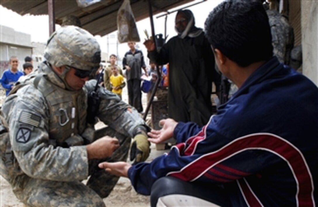 U.S. Army Staff Sgt. Philip Kriner checks for explosive residue on an Iraqi man's hands during a dismounted patrol in Amulshabi, Kirkuk, Iraq, March 11, 2008. Kriner is assigned to the 10th Mountain Division,  Delta Company, 2nd Battalion, 22nd Infantry Regiment, 1st Brigade Combat Team. 