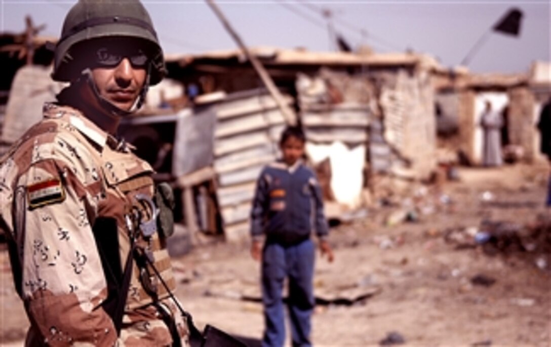 An Iraqi army soldier provides security during a patrol in Abu Atham, Iraq, March 5, 2008. The soldier is assigned to the 9th Iraqi Army Division's 1st Tank Battalion, 2nd Battalion.