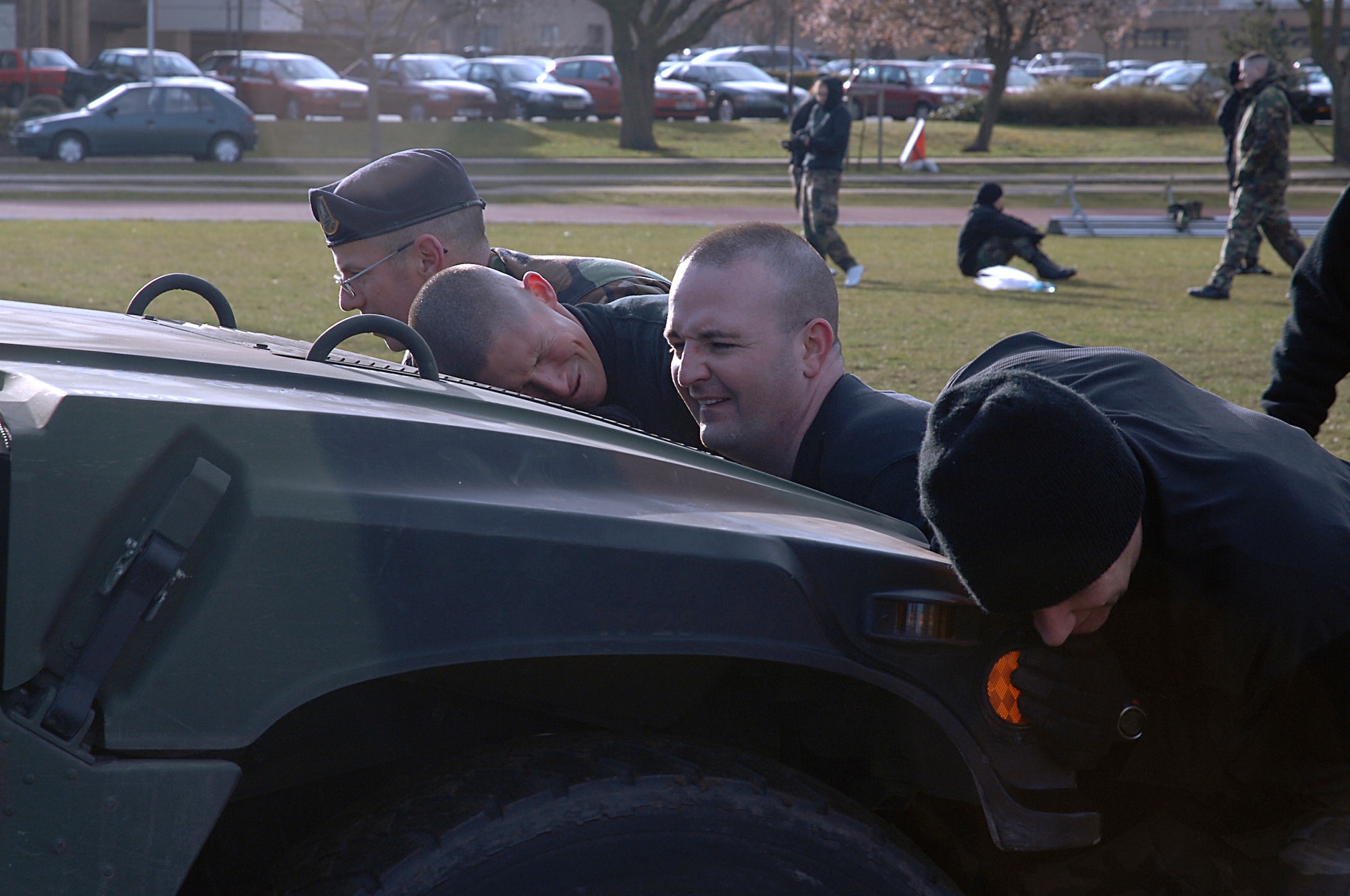 Chief Master Sgt. Bob Henson (left) lends a helping hand to Senior Airman Erik Wertman, Tech. Sgt. Bill Bequette and Master Sgt. Robert Hoyt to push a 6,000 pound HMMWV during the 48th Security Forces Squadron Combat Olympics March 11 at RAF Lakenheath, England. All four team members had to push the vehicle 40 yards one way and then push the vehicle back another 40 yards to the starting line. The event tested everyone's muscular strength and endurance which could be needed when carrying a fallen Airman in battle, moving needed supplies or pushing an attacked vehicle out of the roadway. (U.S. Air Force photo by Senior Airman Brian J. Ellis)
