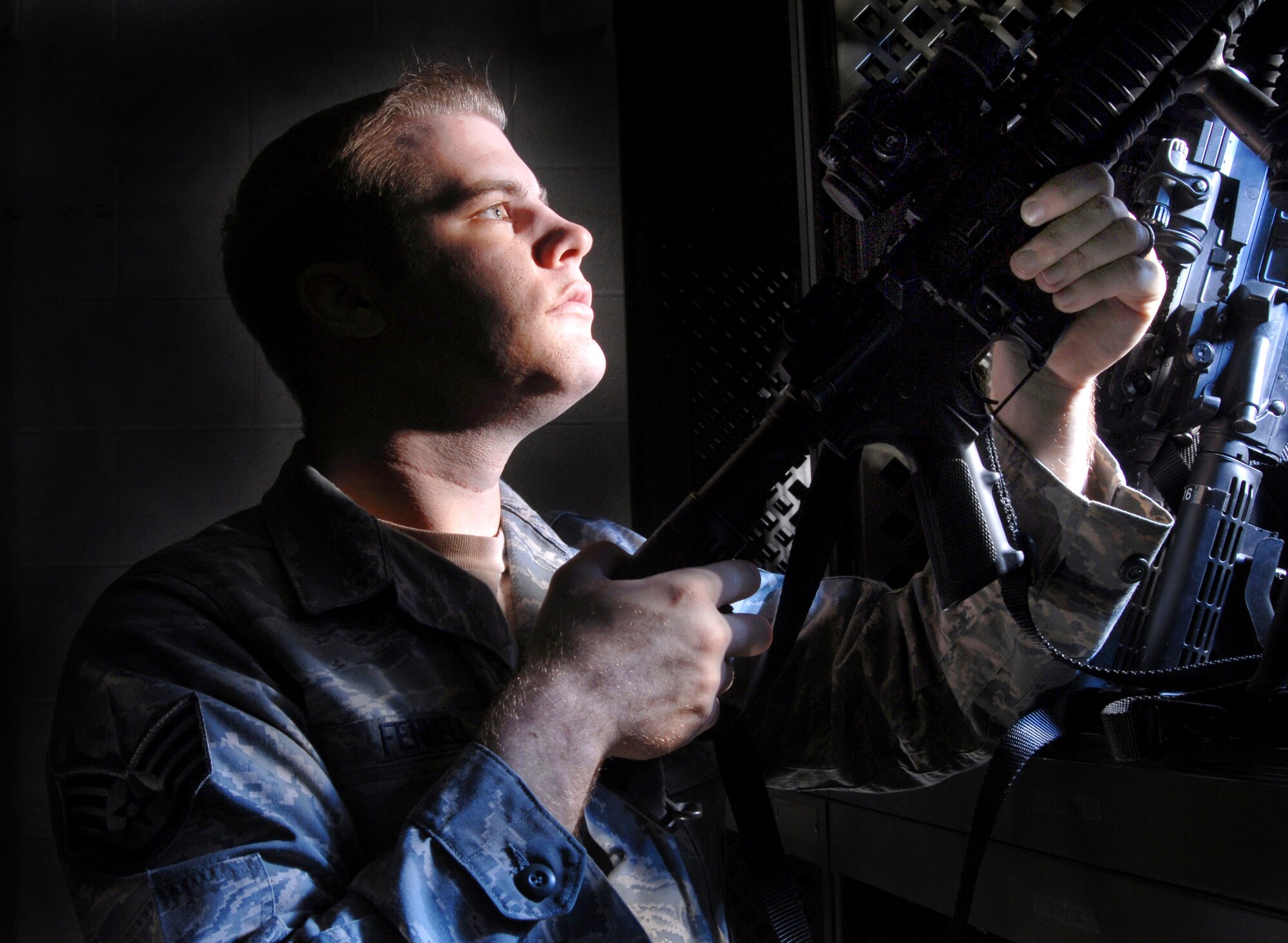 Staff Sgt. Andrew Fennell, an armorer from the 452nd Security Forces Squadron, March Air Reserve Base, Calif. visually inspects a 5.56 mm M4 carbine rifle at the armory. (U.S. Air Force photo by Val Gempis)