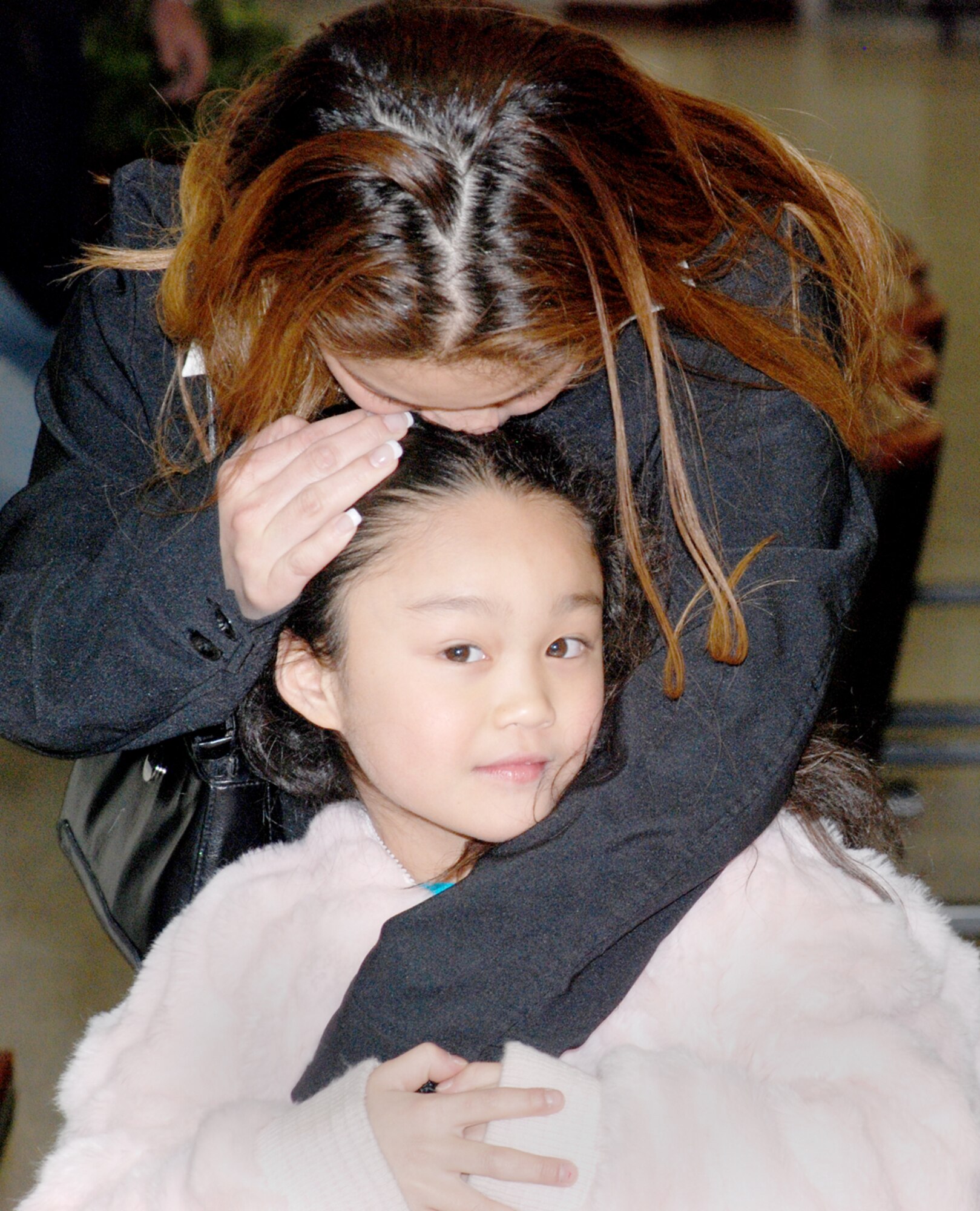 Senior Airman Alicia Tamura, 90th Maintenance Operations Squadron, hugs her daughter upon returning to the Cheyenne Regional Airport Feb. 29 from a four-month deployment to Fort Bragg, N.C. Airman Tamura was deployed for training requirements, acting as personnel support for contingency operations. She performed both personnel functions and accountability (U.S. Air Force photo/Airman 1st Class Daryl Knee).